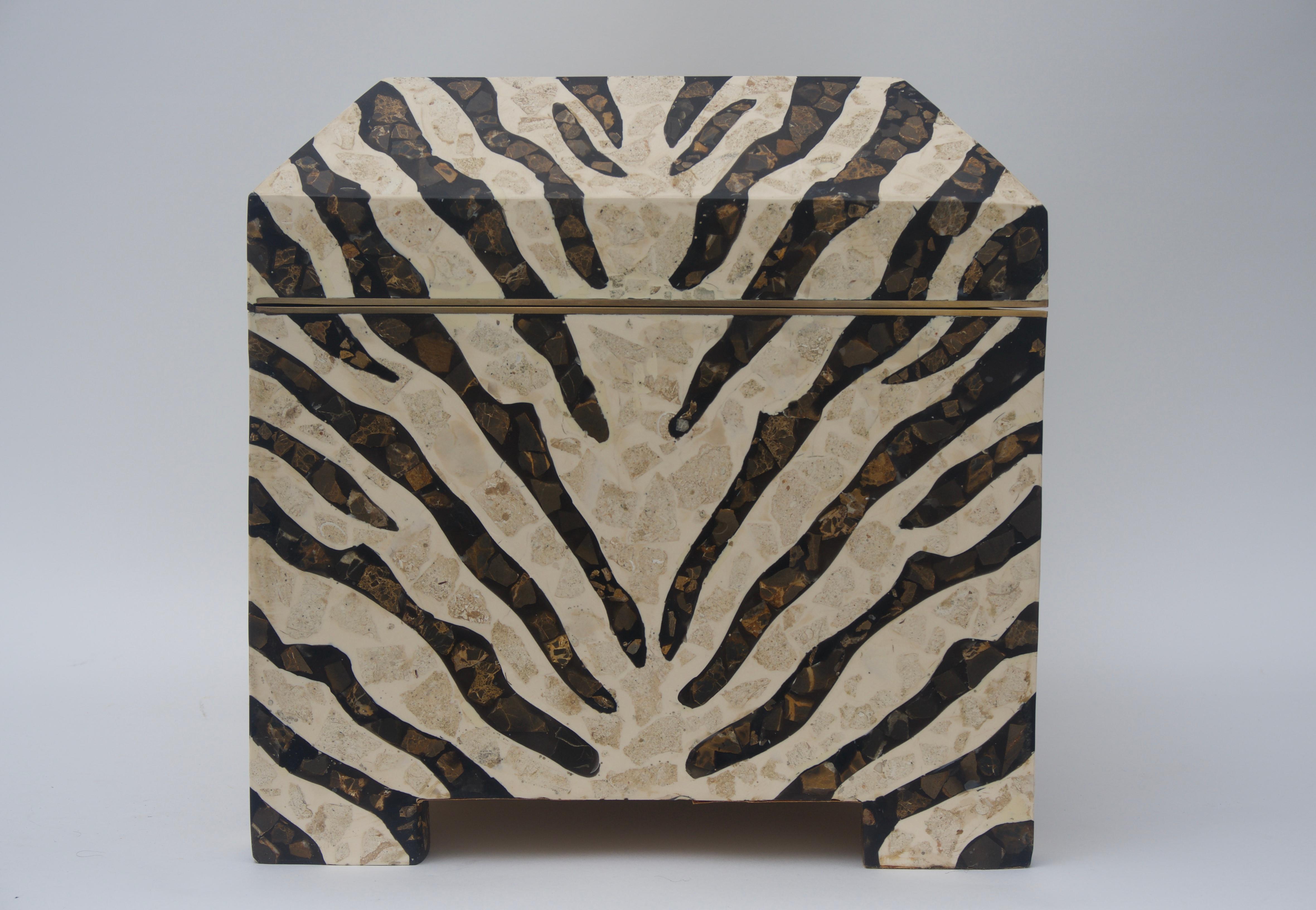 This large scale stylish piece is dates to the 1980s and was created by Maitland Smith. The zebra stripe motif is fabricated in marble veneers, polished brass and the interior has a beige faux suede lining.