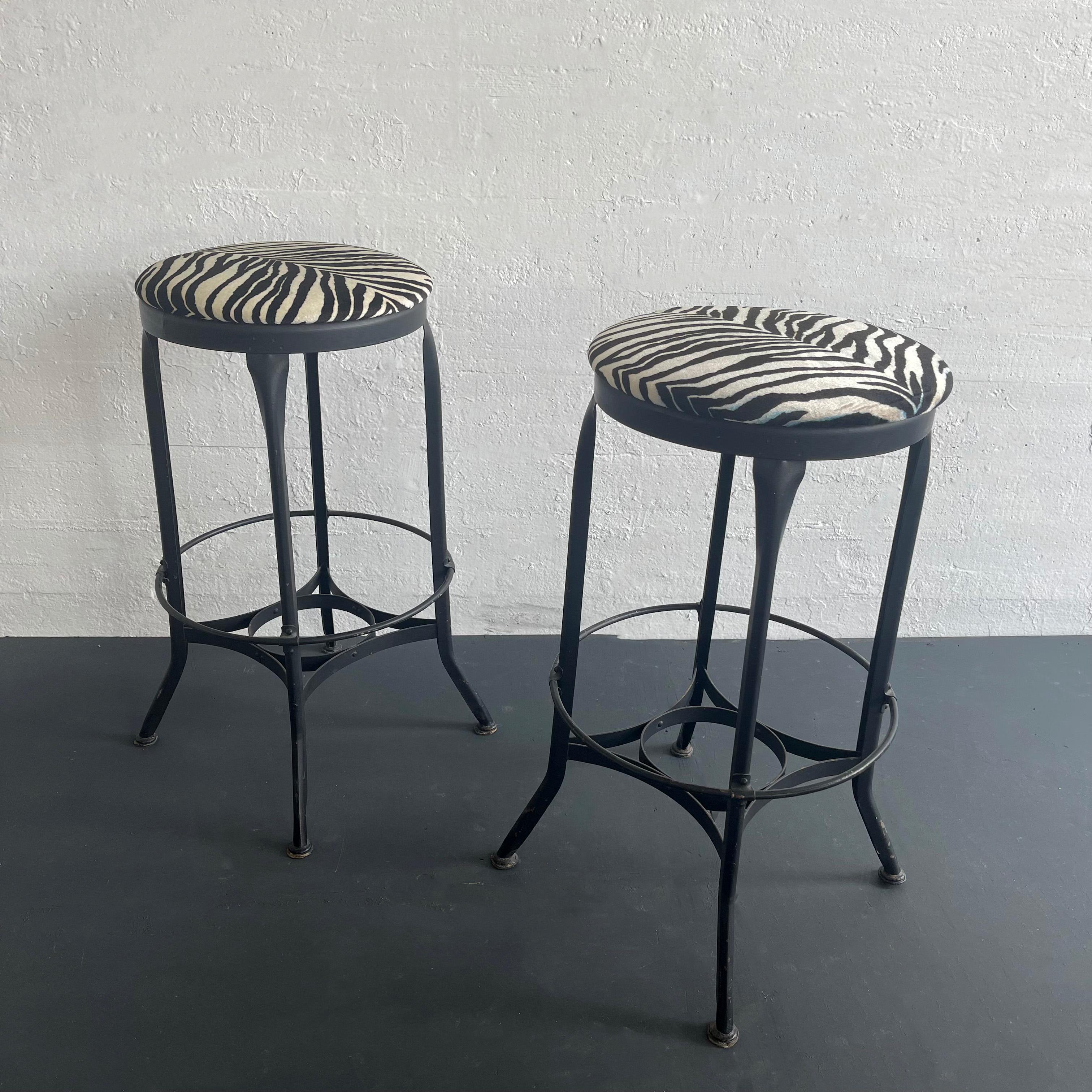 Pair of tall, industrial, shop stools by Toledo Metal Furniture Co. are bar height. The pair feature painted steel frames with the classic Toledo star footrests that measure 17 inches diameter and 12 inches height. The 15 inch diameter seats have