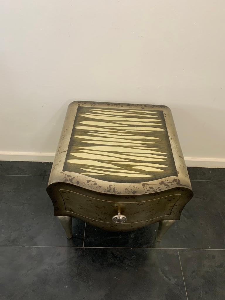 Table basse avec tiroir de la série Zebra par Lam Lee Group/O.L.F., années 1990. Le corps aux lignes sinueuses repose sur des pieds allongés en pomme de pin argentée. Laqué ivoire et fini au pinceau avec effet zébré, il est fini sur le devant en