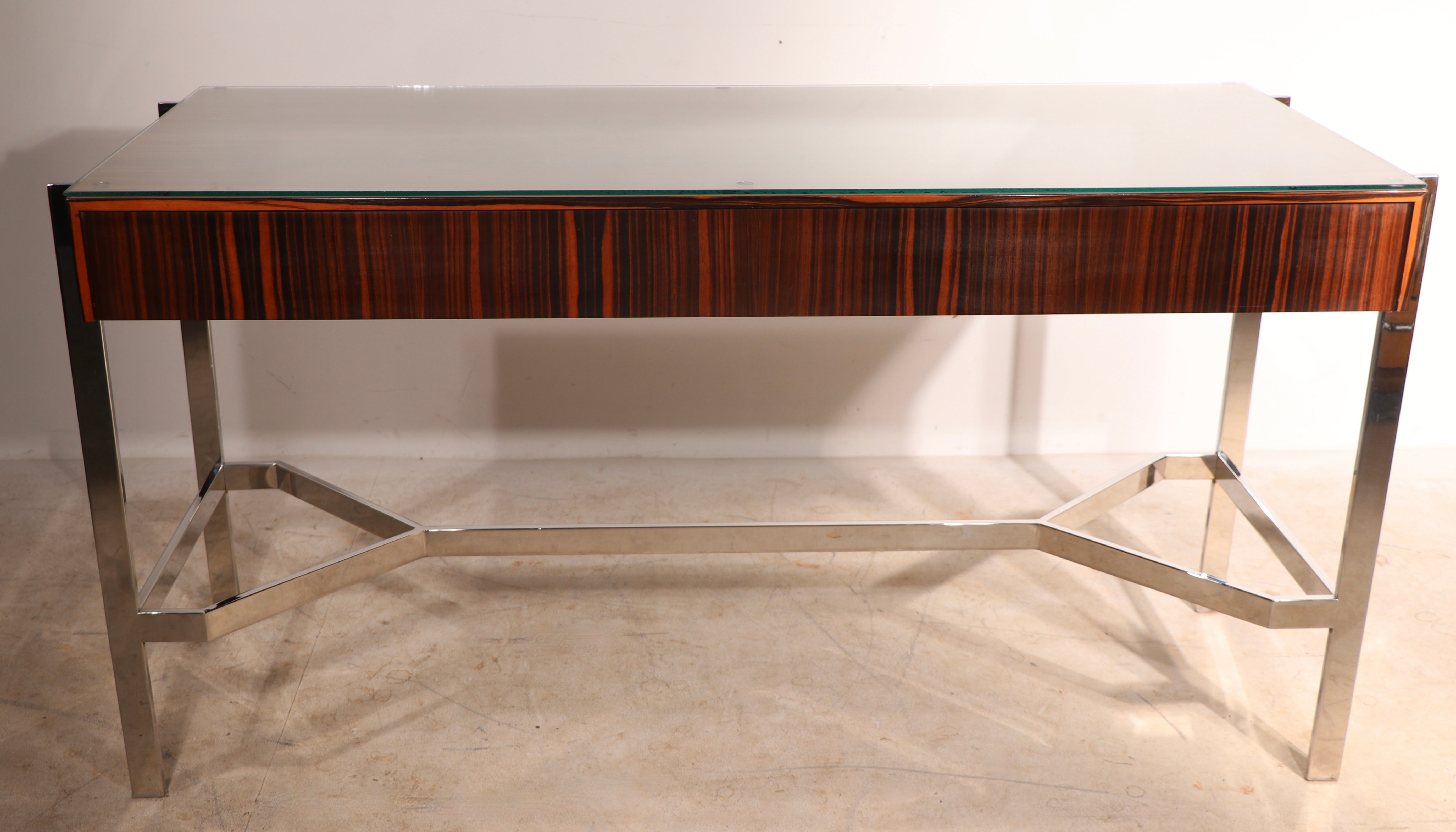 High style 1970’s writing desk, of stunning zebra wood veneer, on an architectural bright chrome frame.
The rectangular wood element features three pull out drawers, it is 5 in. H.
This fabulous desk was originally purchased at the chic and famous