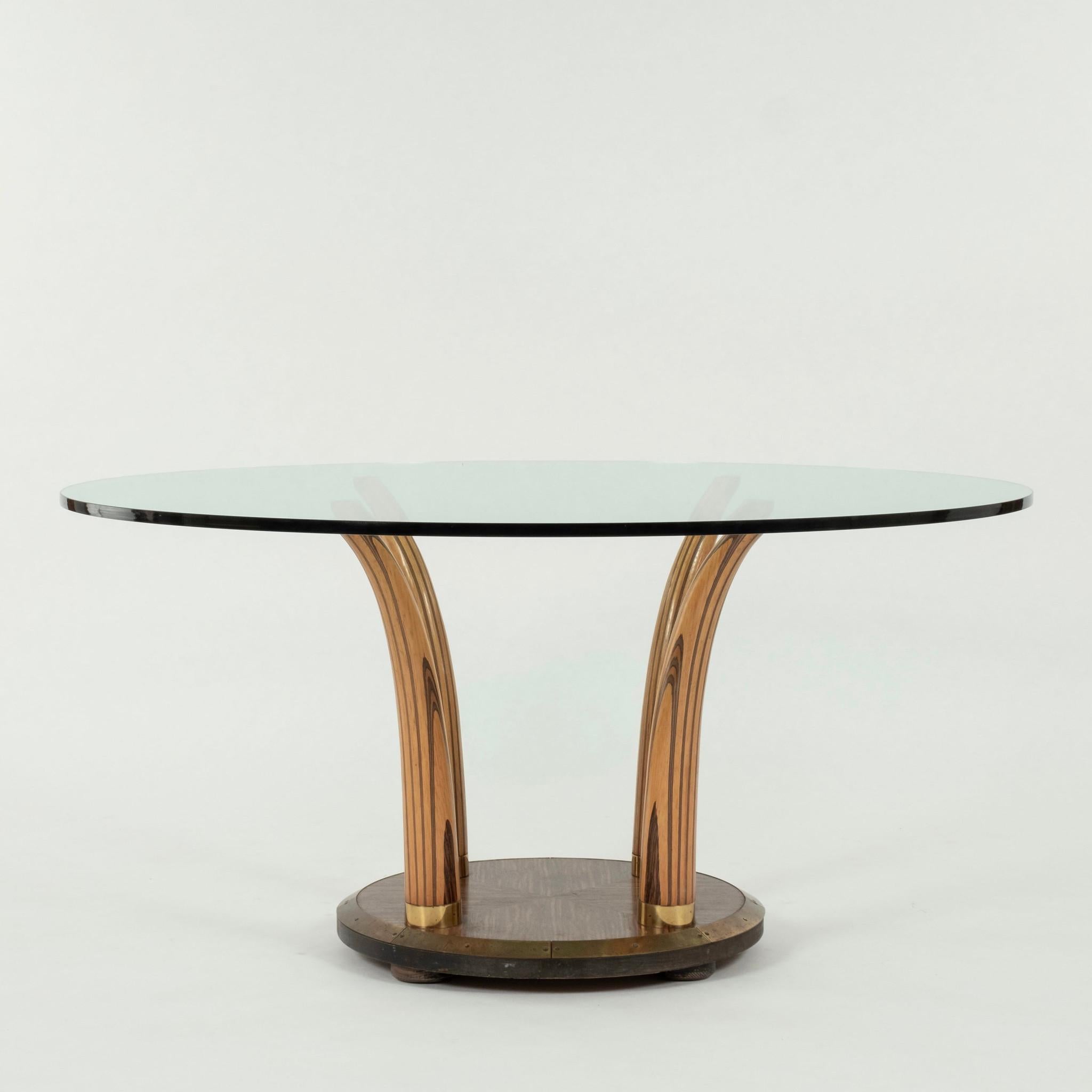 20th Century mixed zebra wood dining table: circular brass lined beveled base with four faux tusks supporting a 3/4