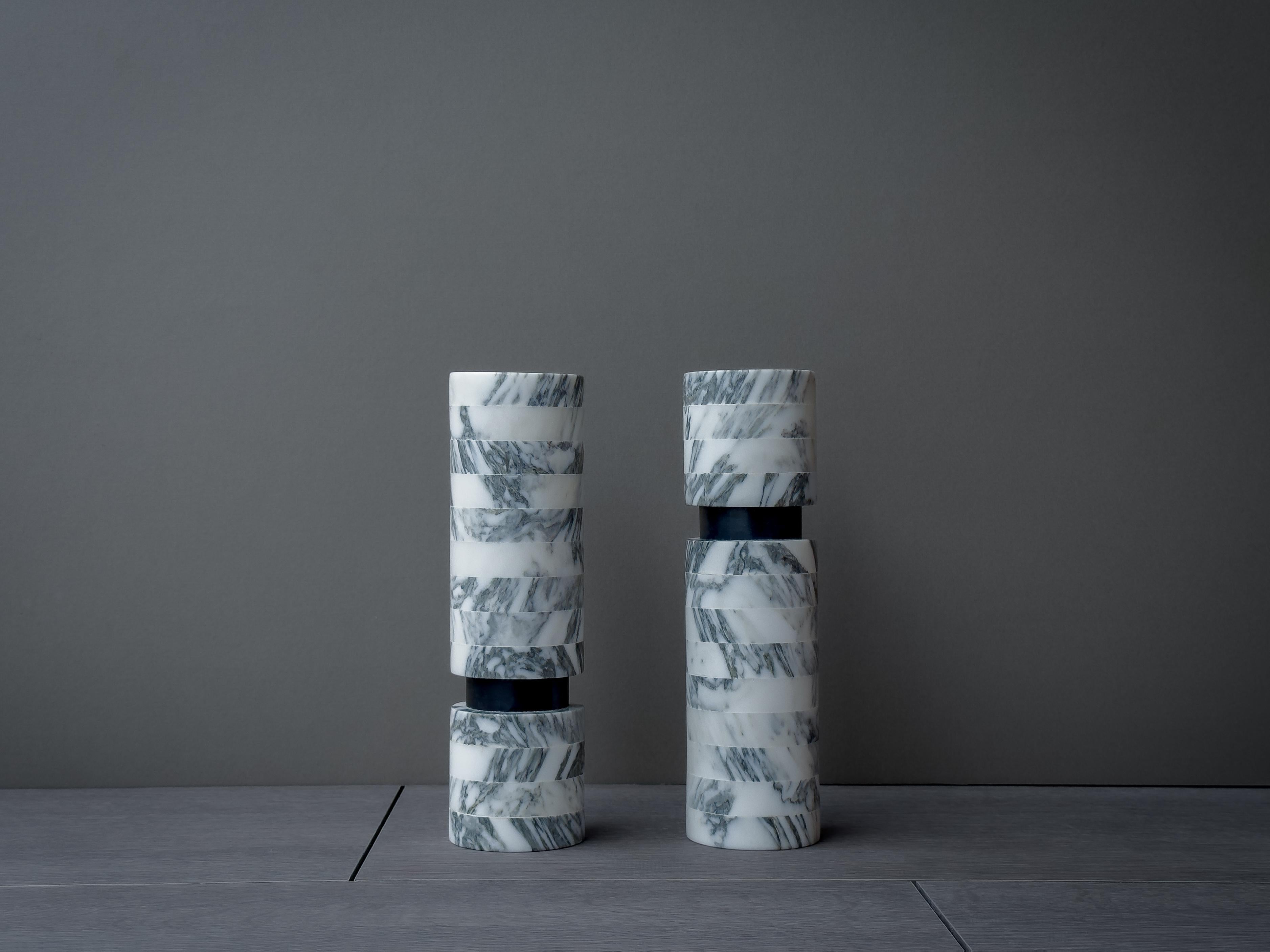 Meticulously crafted, this cylindrical vase showcases the captivating beauty of Arabescato marble. The swirling patterns of black and white gracefully intertwine, creating a mesmerizing display reminiscent of fine art. Each vein tells a unique