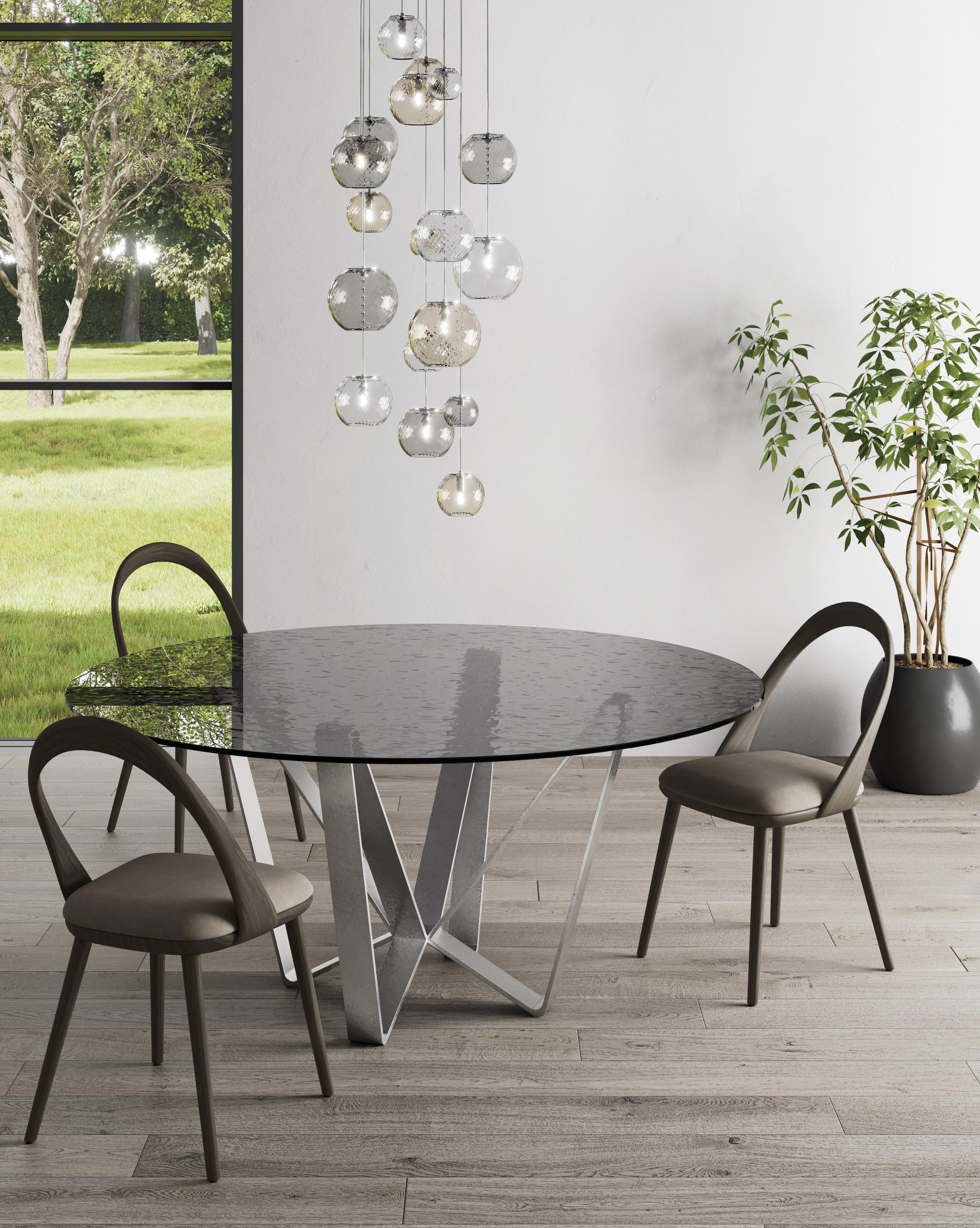 Zefiro Dining Table by Chinellato Design
Dimensions: D 1400 / 1600 x H 71.7 cm
Materials:
Top: Smoked hammered tempered glass.
Base: Chabin silver leaf-finished.


Round dining table available in two sizes, offered with three combinations of base