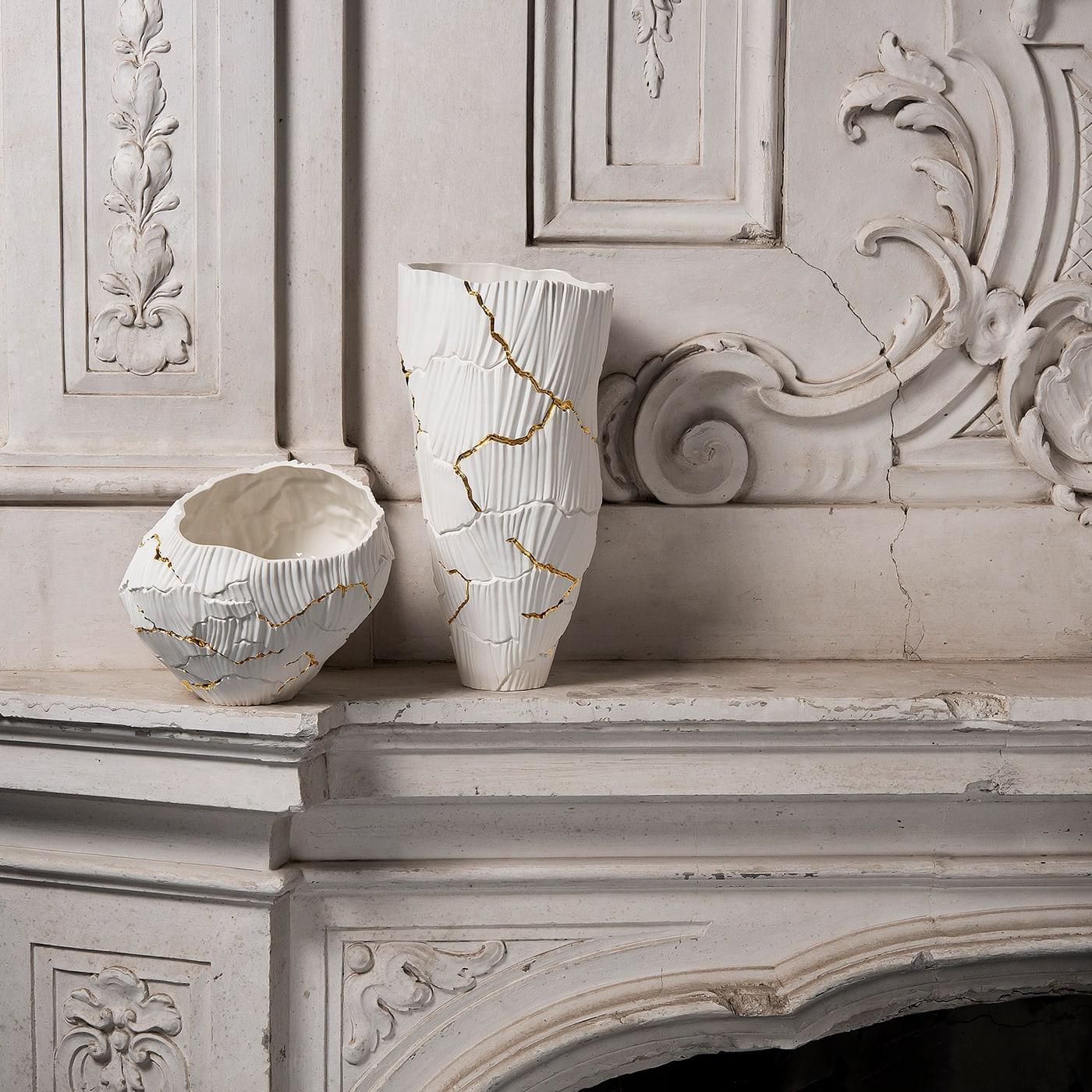Zefiro is a sophisticated porcelain decorative bowl, part of Anemos Collection. The soft curves of canals shaped by wind create a unique rhythm on the surface, interrupted by deep cracks, like a dry land that discloses a precious secret. The pure