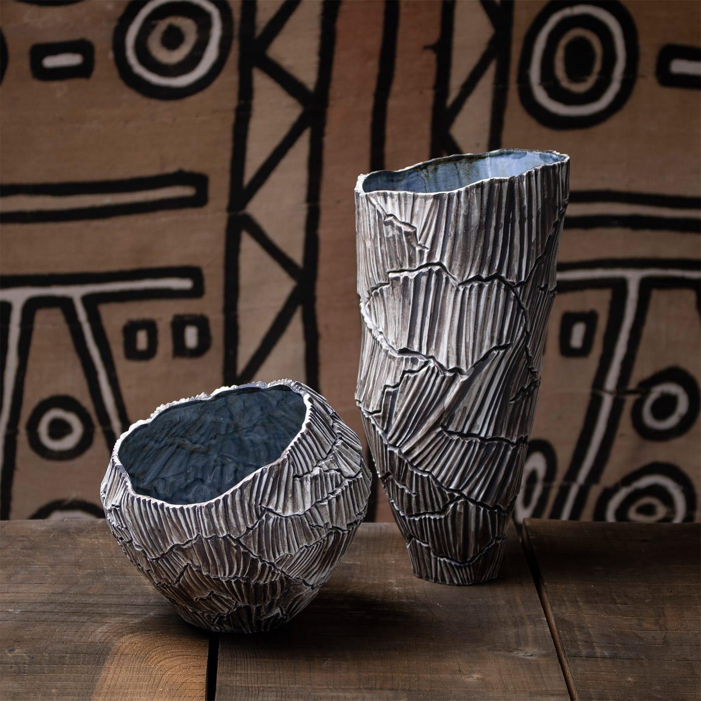 Zefiro Rock ist eine dekorative Schale aus Porzellan, die zur Collection'S von Anemos gehört. Die sanften Kurven der vom Wind geformten Kanäle erzeugen einen einzigartigen Rhythmus auf der Oberfläche, der von den tiefen Rissen des trockenen Landes