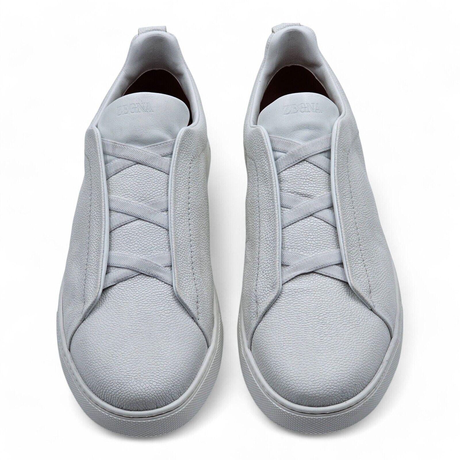 Zegna Triple Stitch Sneakers Leather in White.

Additional information:
Material: Textured leather upper
Rubber bottoms
Slip-on style
'XXX' raised logo on heel
Color: White
Size: 12.5 US
Country: Italy
Condition: Brand new without the box. Minor
