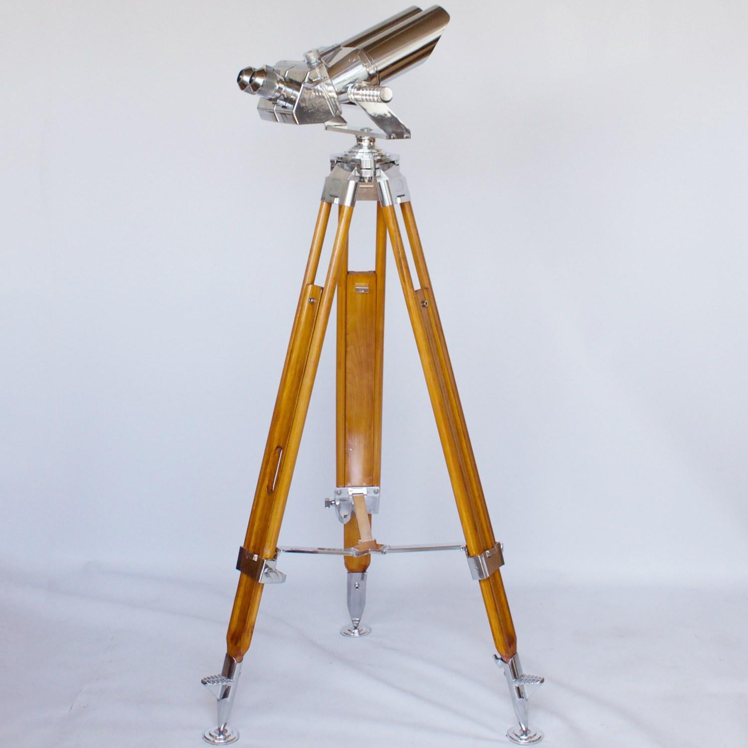 10x80 Zeiss naval binoculars with eyepieces set at 45 degrees. Set on period, extending wood and brass stand with chromed conical feet. 10 times magnification with 80mm objective lens.

Dimensions: H with stand 1m - 1.5m, Barrel L 21cm, Total L