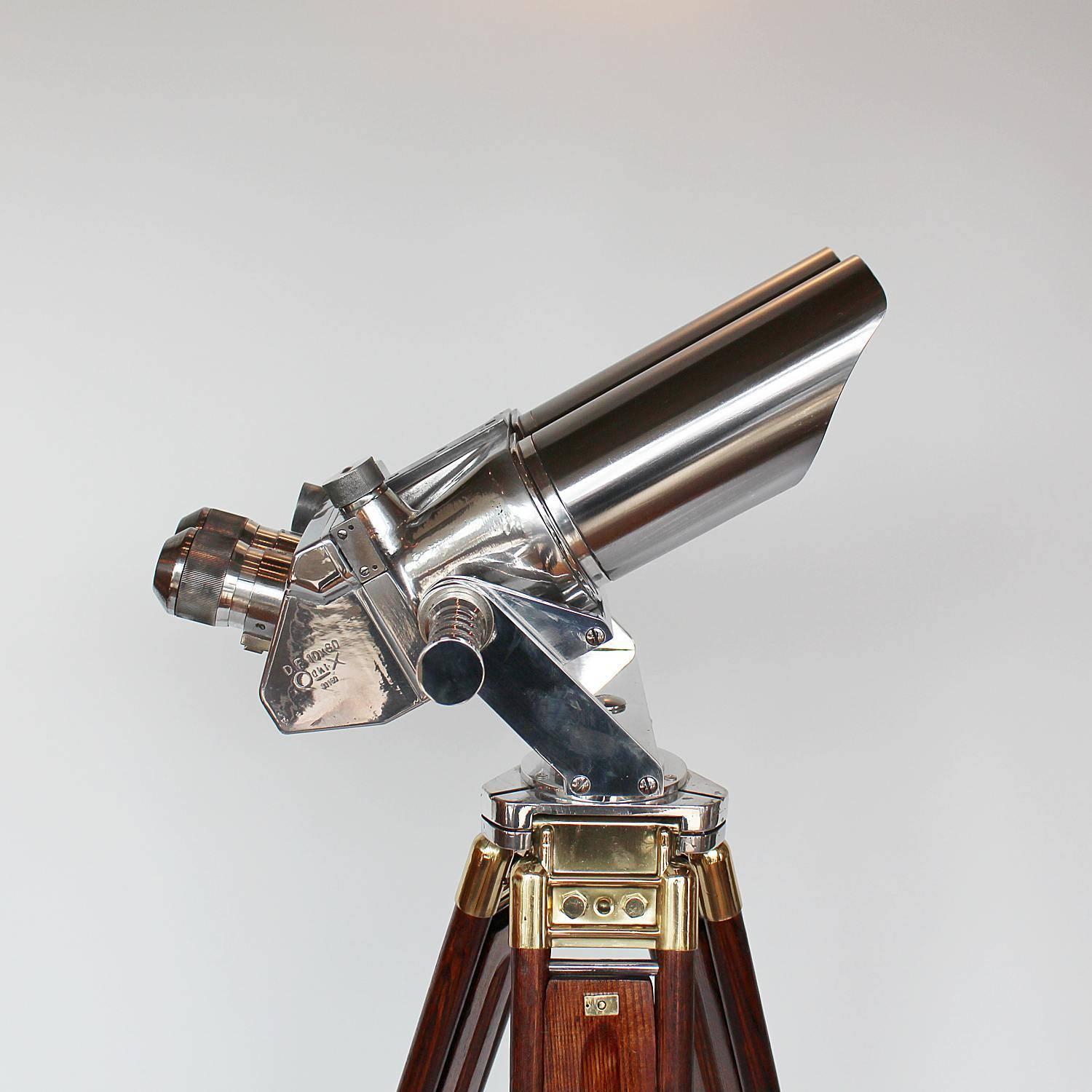 A pair of Zeiss 10x80 binoculars with eyepieces set at 45 degrees. Set on period, extending oak and brass stand with chromed conical feet by Zeiss. 10 times magnification with 80mm objective lens.
Paint stripped and metal polished. Fully