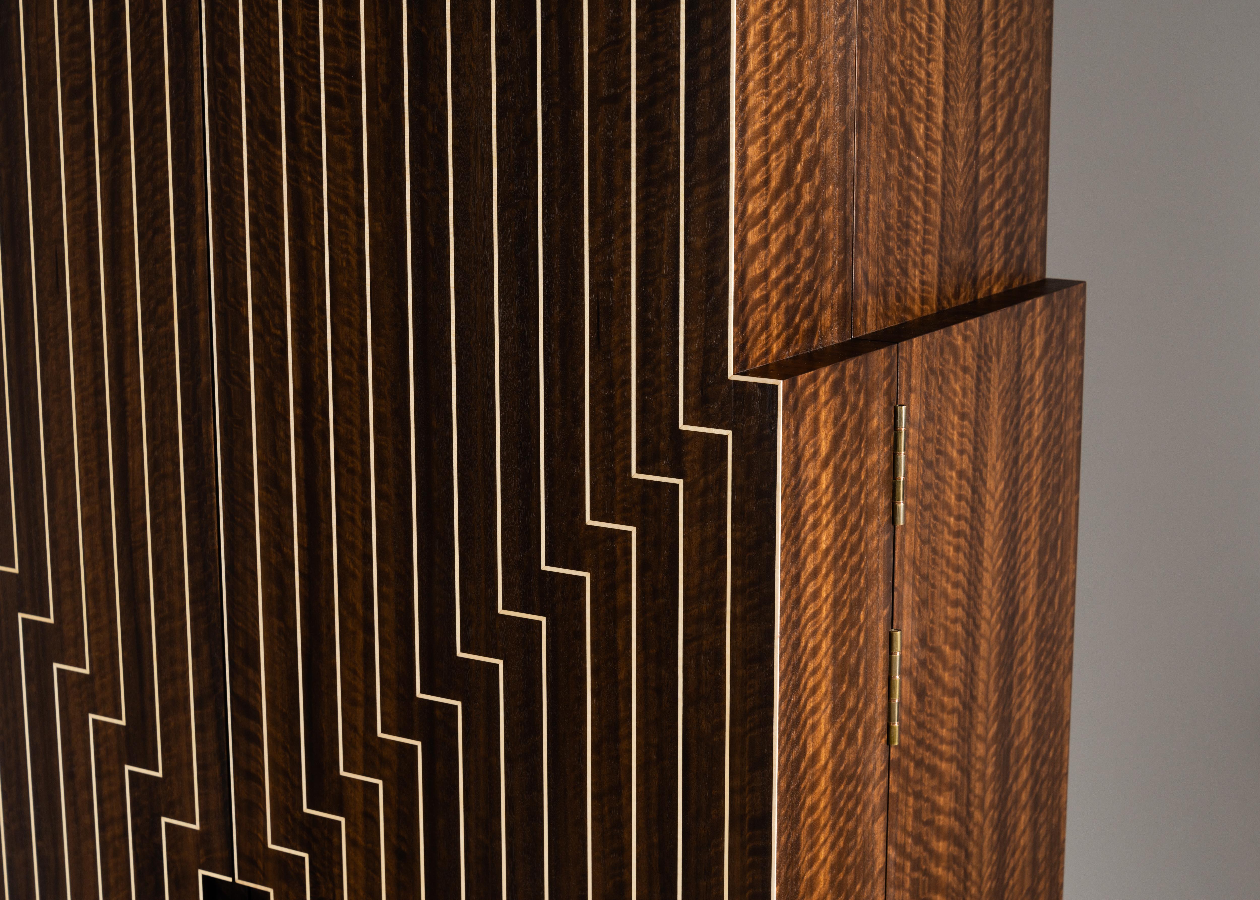 Edition of 6 + 1 AP.

Influenced heavily by the visionary artist Frank Stella's painting Six Mile Bottom, this cabinet draws the eye to its center with hypnotizing concentric lines. Its Eucalyptus doors are inlaid with ripple sycamore and grounded