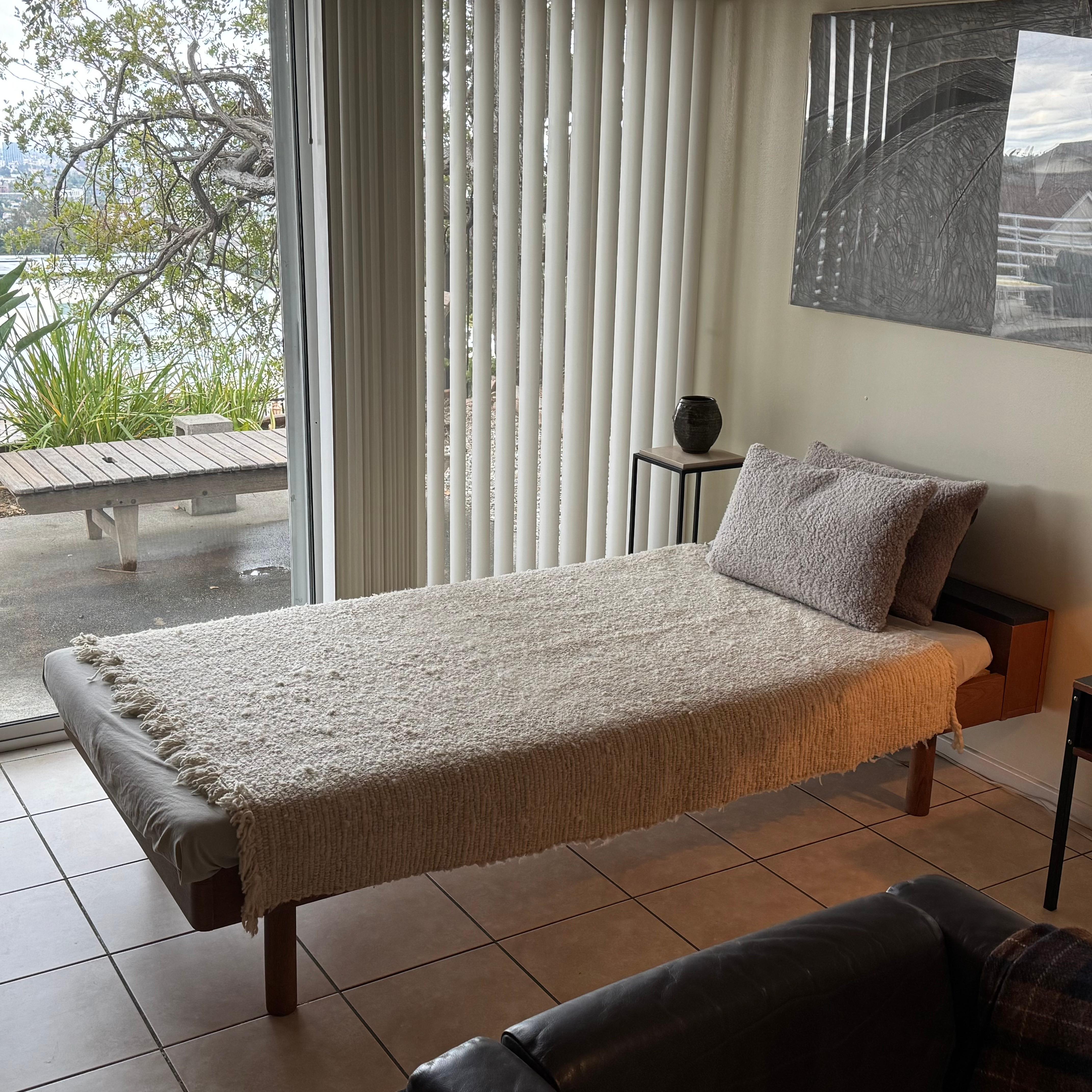 Questo letto da giorno giapponese è un esempio di eleganza minimalista grazie alle linee pulite, al profilo basso e alle calde tonalità del legno naturale.
Il suo design sobrio si integra perfettamente sia negli interni moderni che in quelli