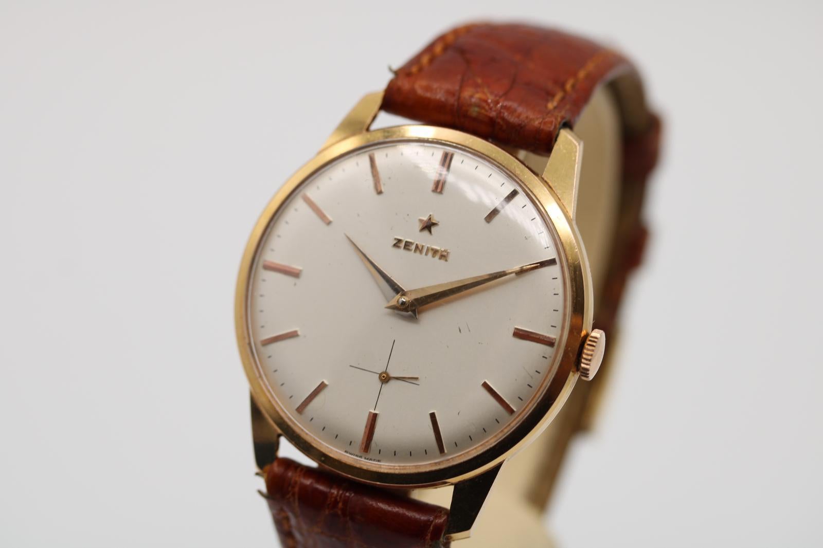 Ein wirklich beeindruckendes Beispiel für das Design einer Uhr aus der Mitte der 60er Jahre ist diese klassische Zenith-Handaufzugsuhr. 

35-mm-Gehäuse aus Roségold, versilbertes Zifferblatt und Zeiger mit untergeordnetem Sekundenzifferblatt in der