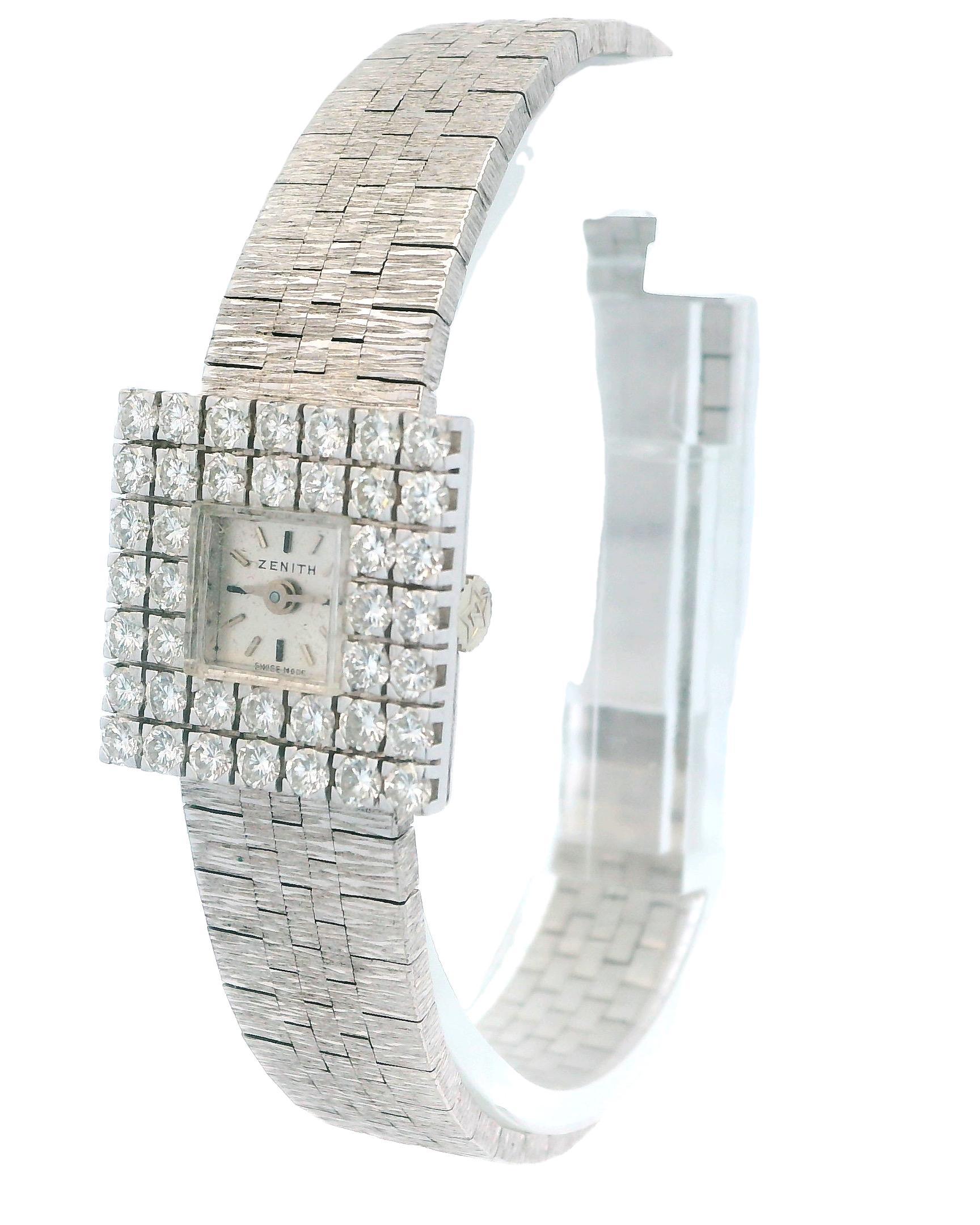 Montre mécanique Zenith pour femme. Boîtier 17,5X17,5mm en or blanc 18k avec lunette sertie de 40 diamants d'usine. Cadran argenté avec aiguilles argentées et index bâtons. Bracelet en maille d'or blanc 18 carats avec fermoir bijoutier en or blanc