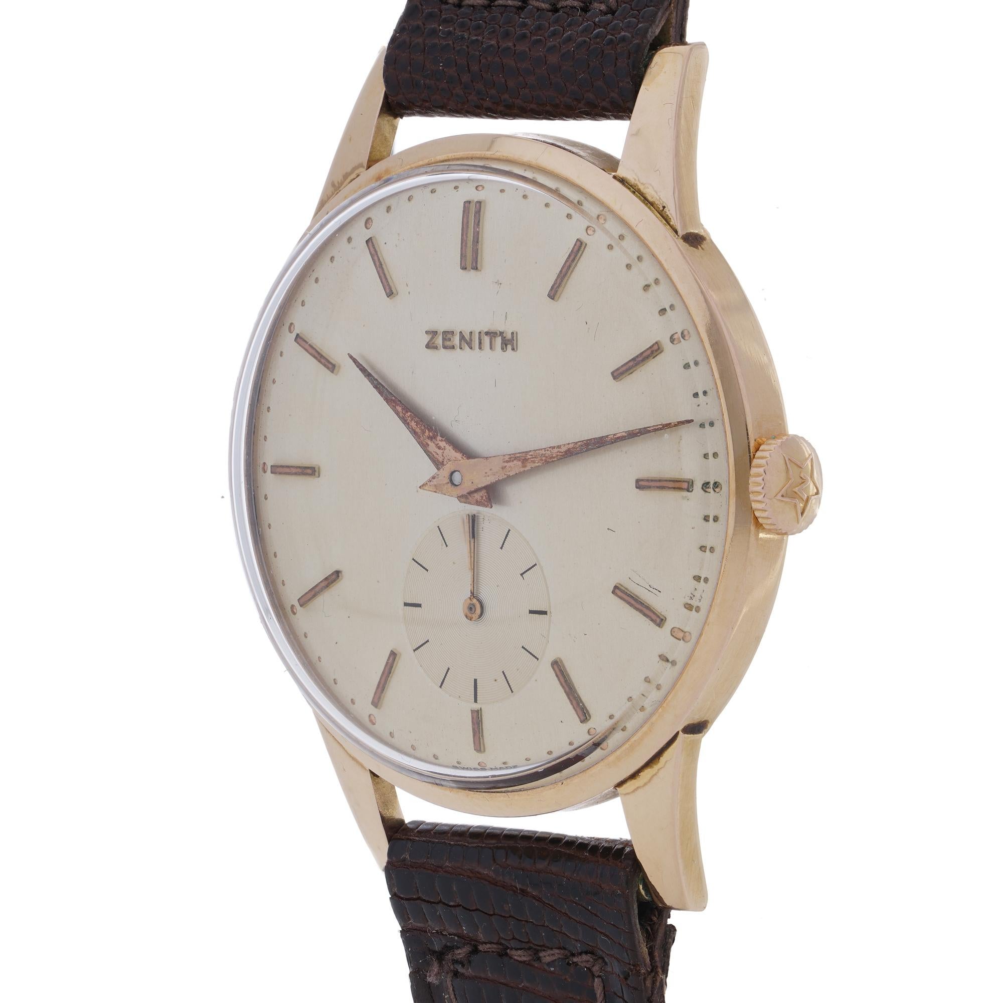 Zenith 18kt Gold Manual Wind Watch.

This classic Zenith wristwatch is crafted in 18kt yellow gold.
Featuring a silver-tone dial with applied gold baton hour markers and sleek gold-tone hands.
The watch includes a subsidiary seconds dial at 6