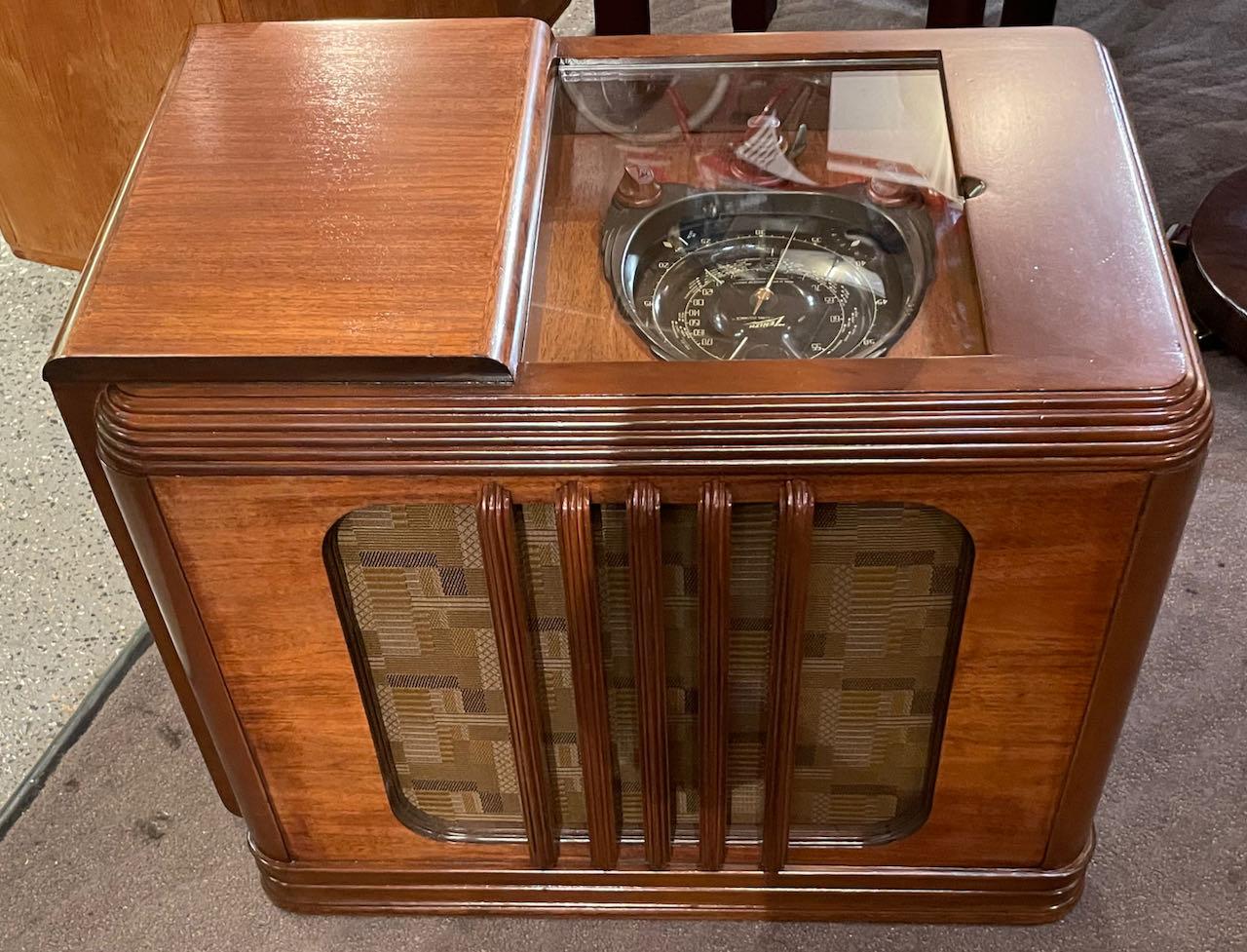 This is a 1938 Zenith 9 tube model 9S244, Zenith’s most famous and collectible year. It is sporting the fabulous “Motor Drive Robot Shutter Dial” and green tuning eye. The large black dial is in very excellent shape. The cabinets’ book-matched