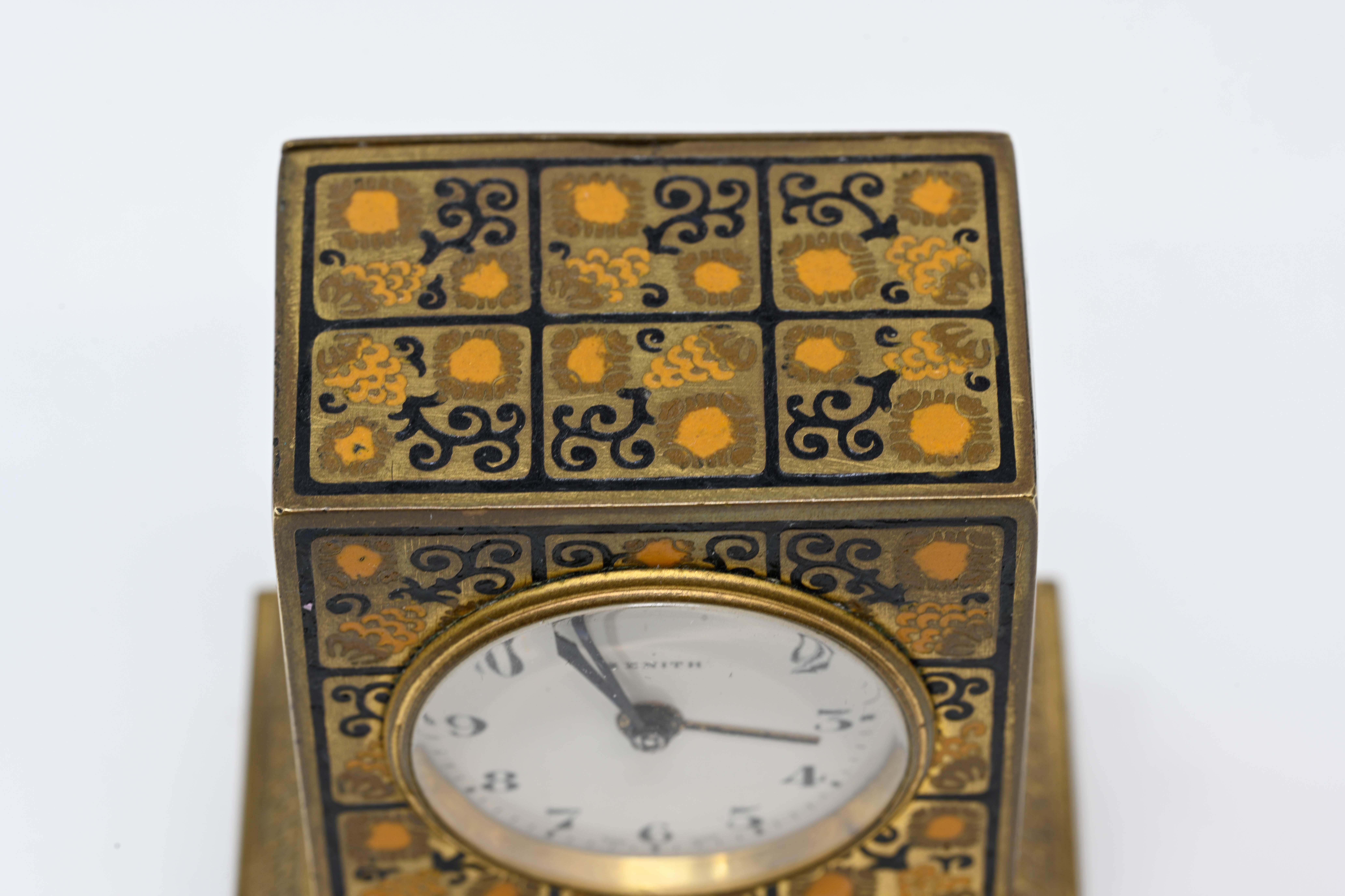Zenith alarm enameled bronze dore travel clock, Swiss made. Enamel dial, signed and numbered on the base 409. In good working order, no box, stands on 4 feet. Decorated with geometric panels signed on the back. Covered metal Dore #6243, measures 2