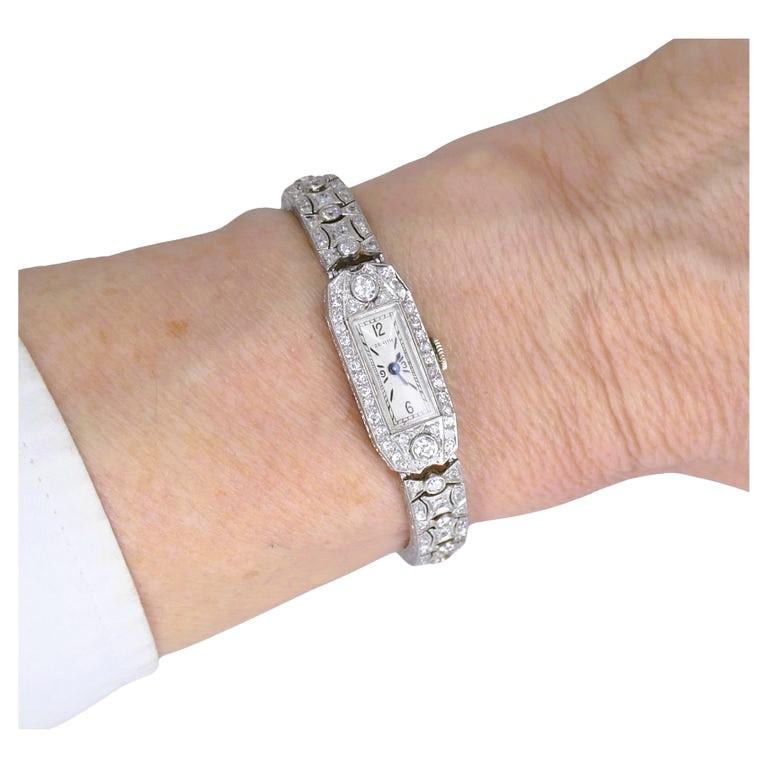 Une exquise montre Zenith de l'époque Art déco, en platine et diamant.
Le boîtier et le bracelet de cette montre Zenith pour dames sont somptueusement ornés de diamants. La gravure florale, qui court en continu sur le bord du bracelet et du boîtier,
