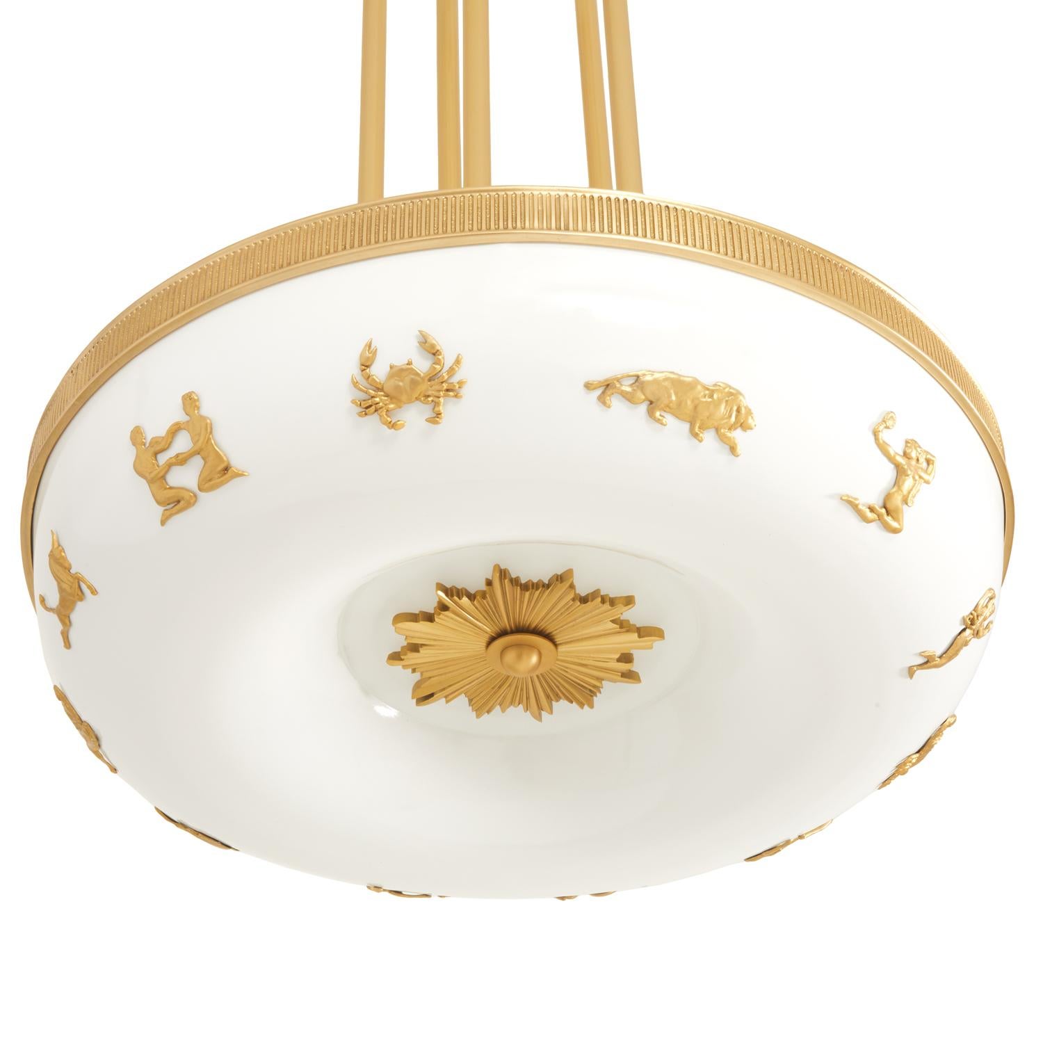 A Swedish Grace period inspired light with cast bronze zodiac signs. This fixture uses a frosted glass insert on the underside, and features a cast bronze sunburst with gold paint finish. Total of seven lights. The Zephyr Zodiac can be customized in