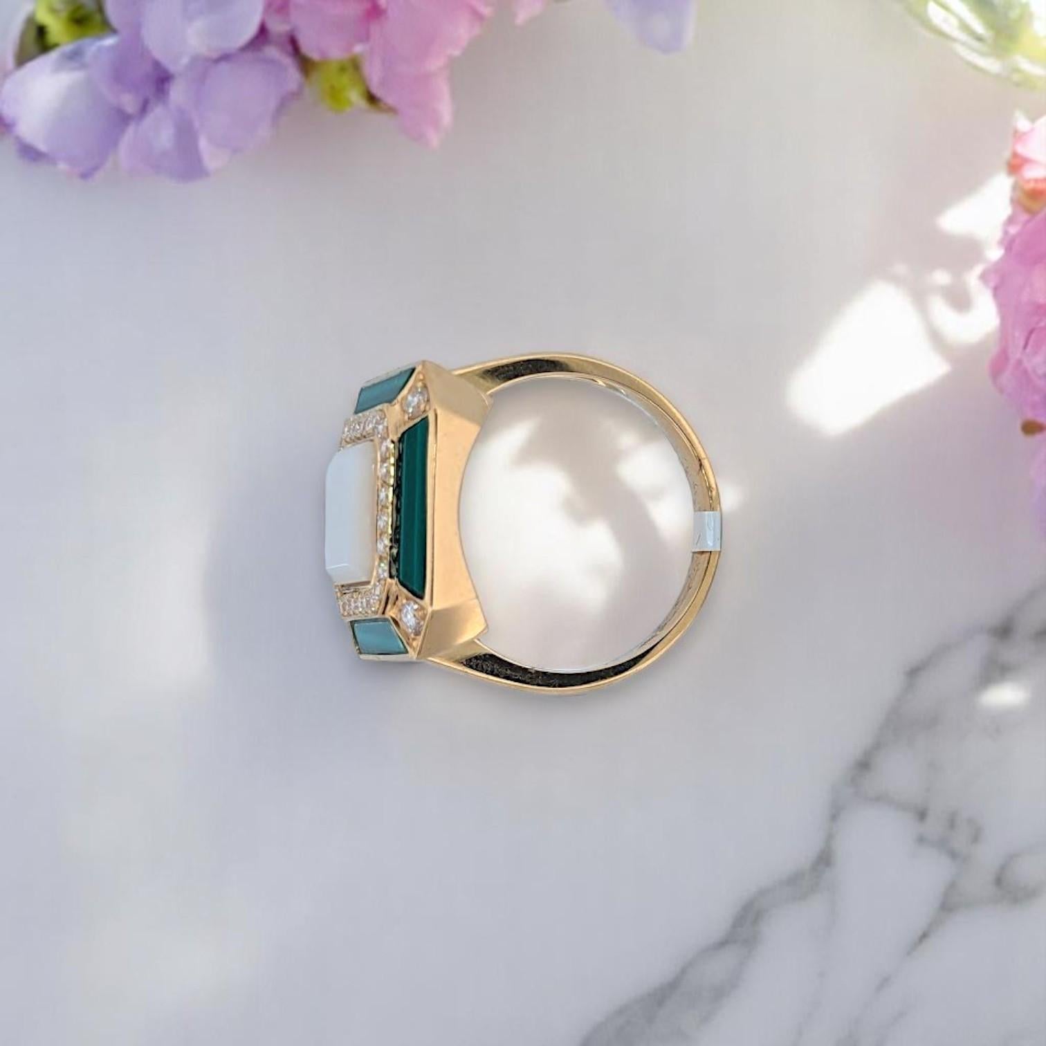 Bring elegance to life with the Zephyrine Verde Ring by Mountain Song Jeweler — a stunning blend of natural gemstones and fine gold. This bold statement piece features a luminous 2.02 ct Mother of Pearl, deep 1.19 ct Malachite, and sparkling .36 ct