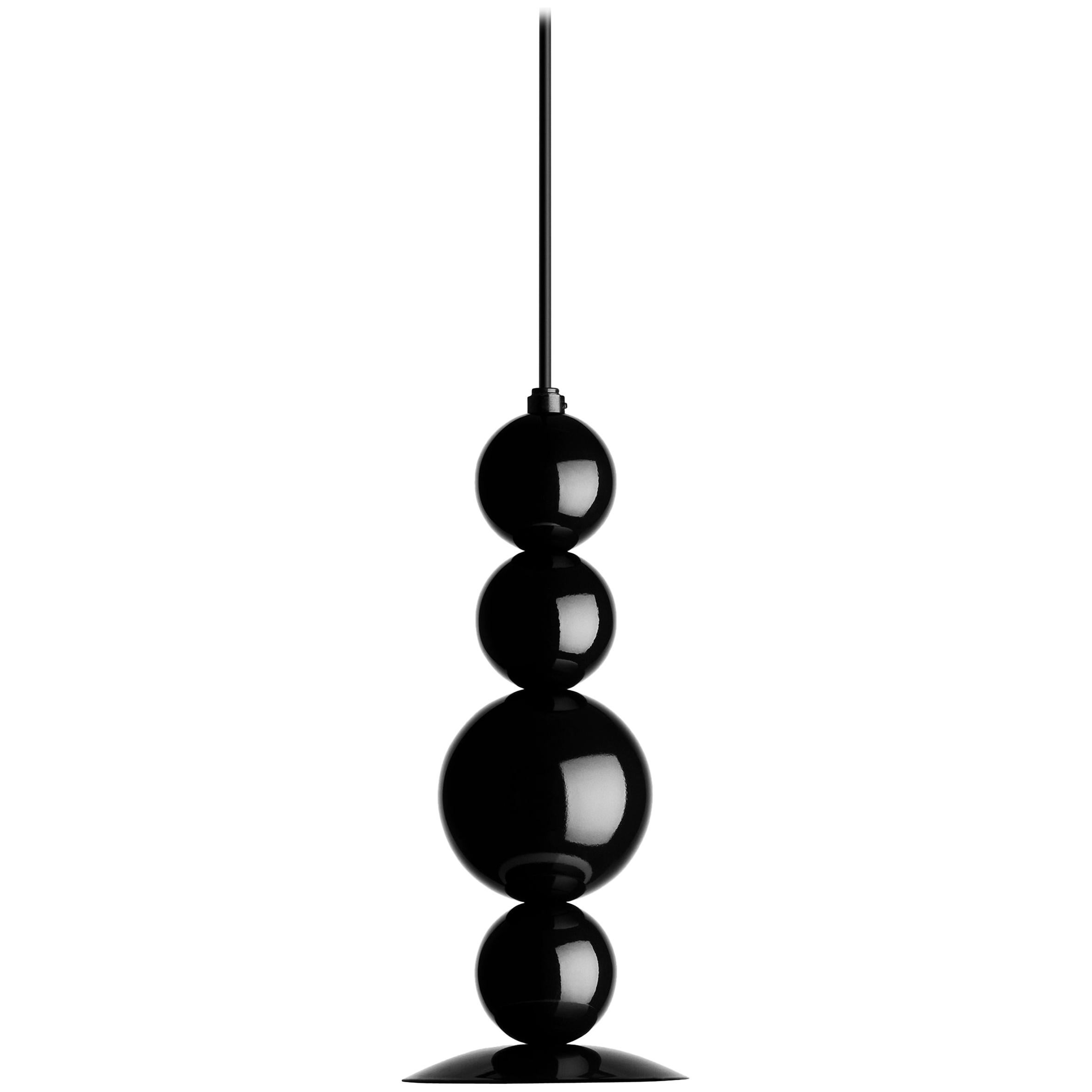 Fredrik Mattson took the idea of “lighting as jewelry” very seriously when designing his RGB pendant with its stacked wooden balls painted in glossy shades of black, green and gold or all black. Punctuated with a white glass globe, the fixture is