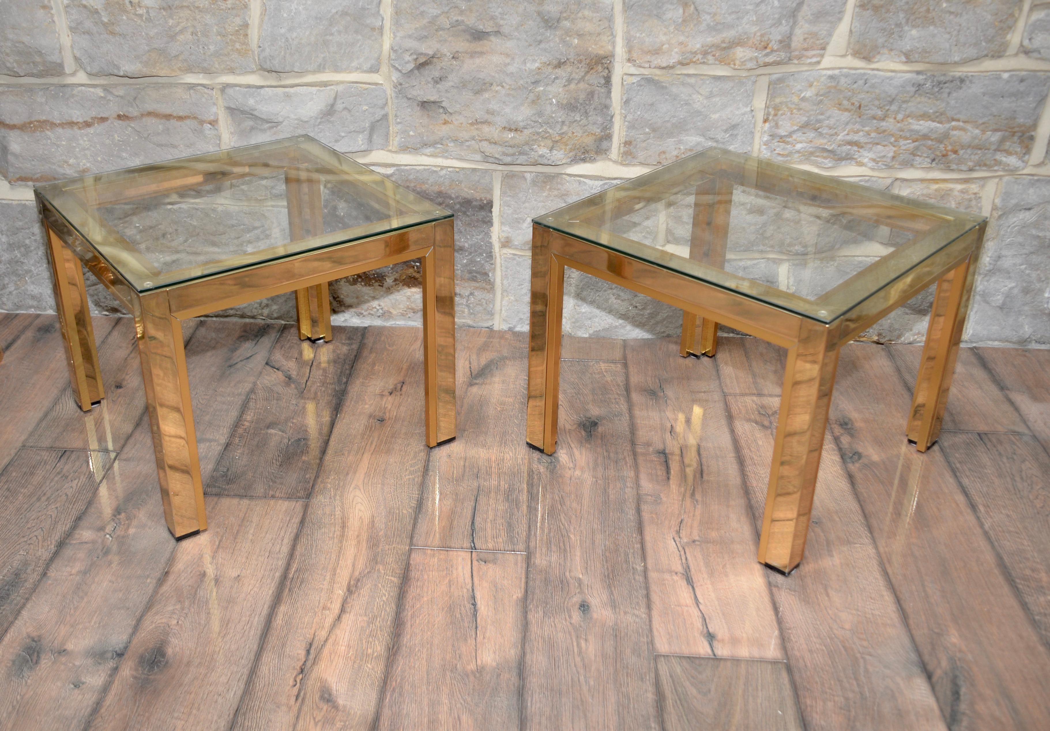 A stunning pair of vintage Italian side tables by Renato Zevi for Romeo Rega. These are a classic vintage design that is well known and well documented in design literature. These tables are gold plated with smoked glass shelves. This listing is for