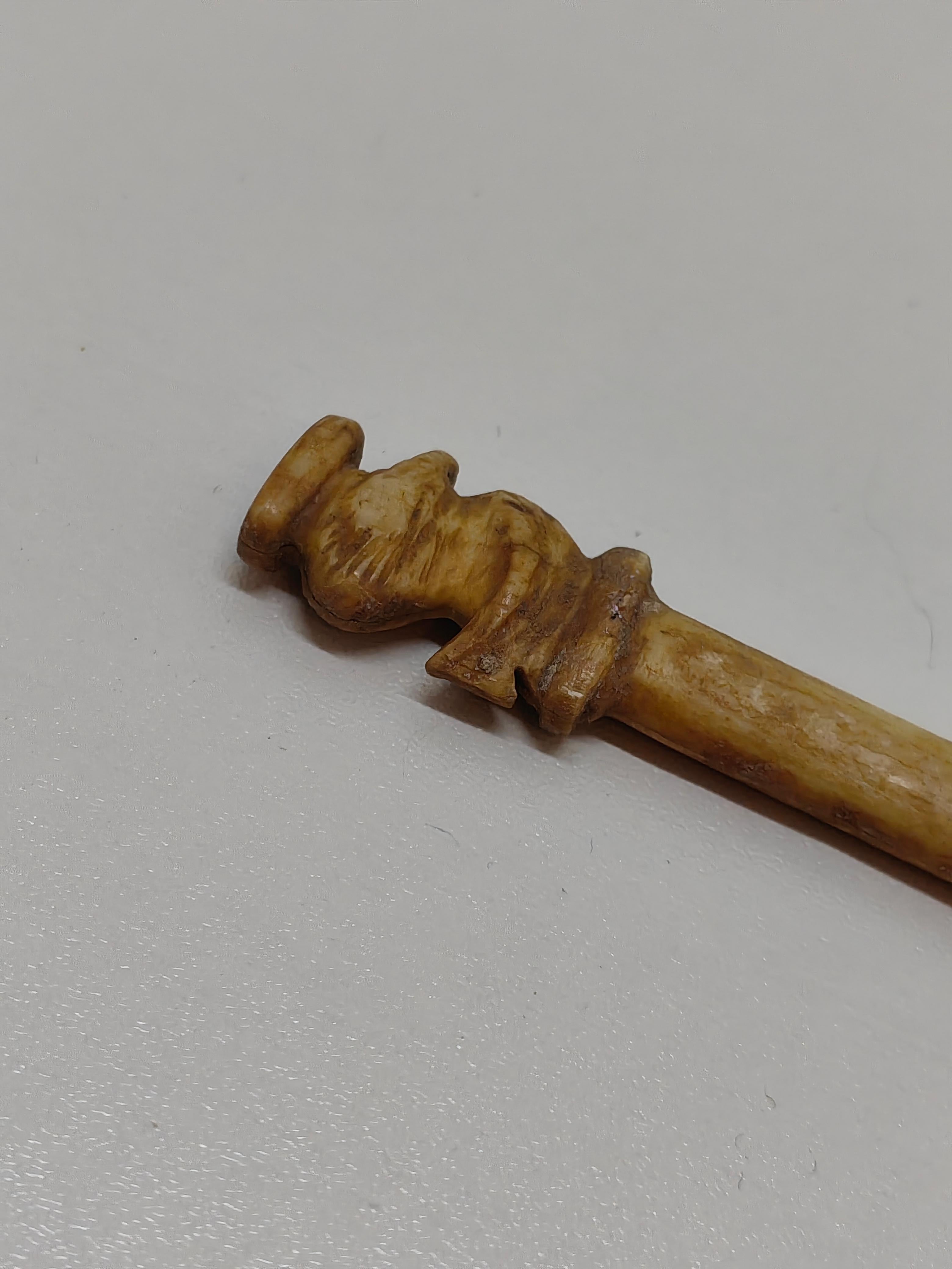 Diese außergewöhnliche Haarnadel aus der Zhou-Dynastie, die fein aus Knochen geschnitzt ist, ist ein fesselndes Artefakt, das die Raffinesse und Kunstfertigkeit des alten China widerspiegelt. Diese mit einem Vogelmotiv geschmückte Haarnadel gibt