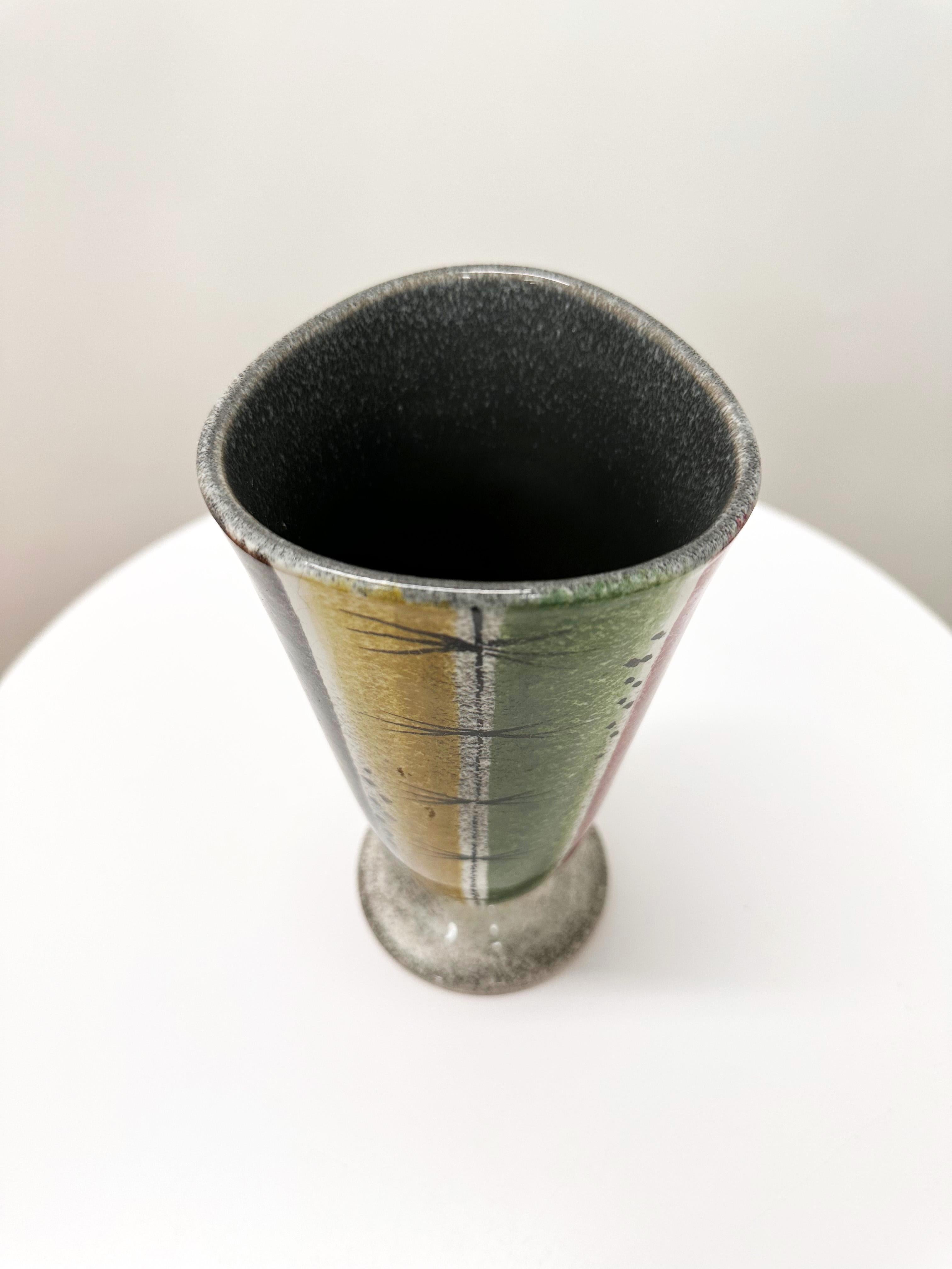 A striking Swiss Mid-Century Modern ceramic vase produced by Ziegler Schaffhausen in the 1950s–60s, attributed to celebrated designer Gustav Spörri.

This hand-decorated vase features a bold painterly design of vertical bands in mustard yellow, moss