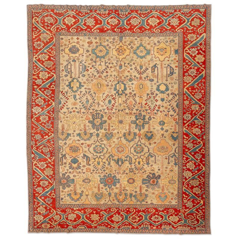 Ziegler Turkish Rug Design of palmettes and flowers in red and blue on a beige background in the central field.

- The rest of the decorative elements follow linked patterns of floral figures and palmette along its border on a red background.

-