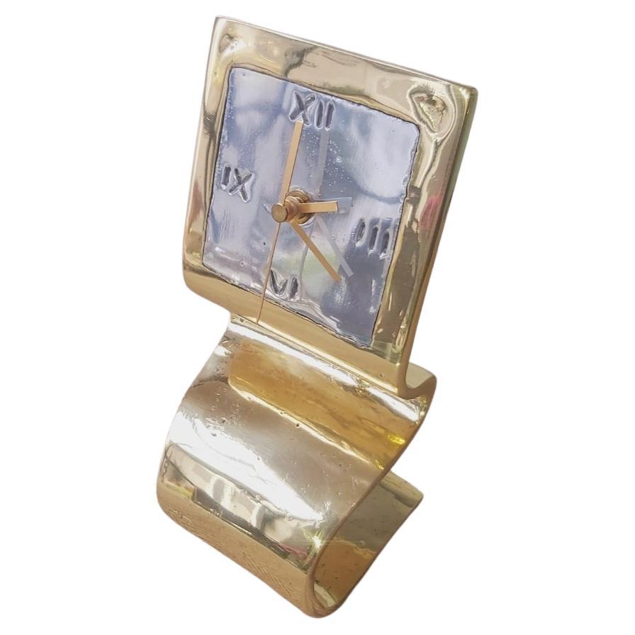 The clock was created by David Marshall, from sand cast aluminium and brass.
 We use recycled materials all our pieces are handmade, mounted and finished in our foundry and workshop in Spain.
It is certified authentic by the Artist David