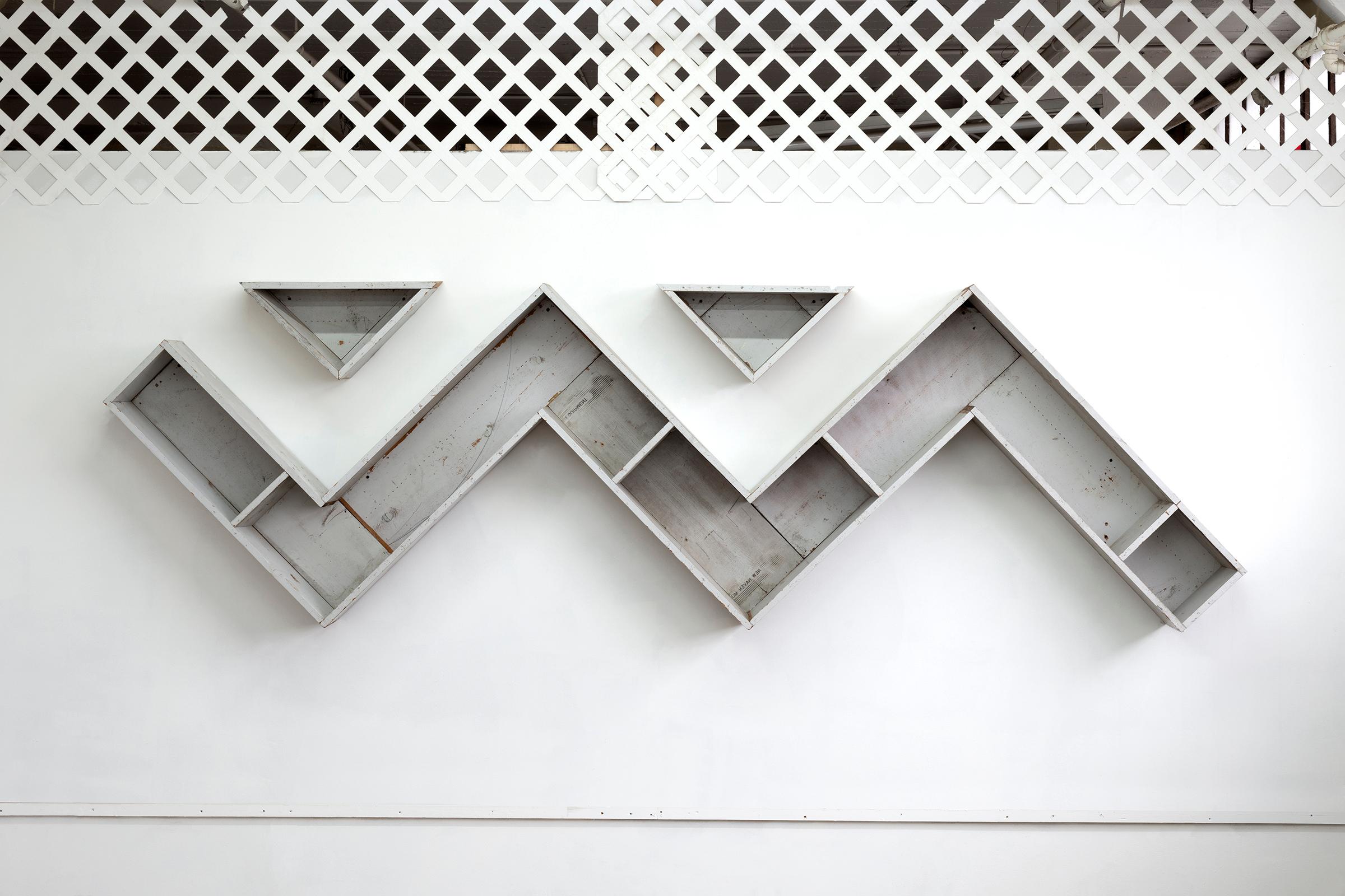 Teague’s Zig Zag Bookshelf, made from materials from the foreclosed and condemned houses of Bronzeville and sourced from the formidable South Side picker, Miss Lady, support Teague’s library of design and Black political theory. Salvaged materials