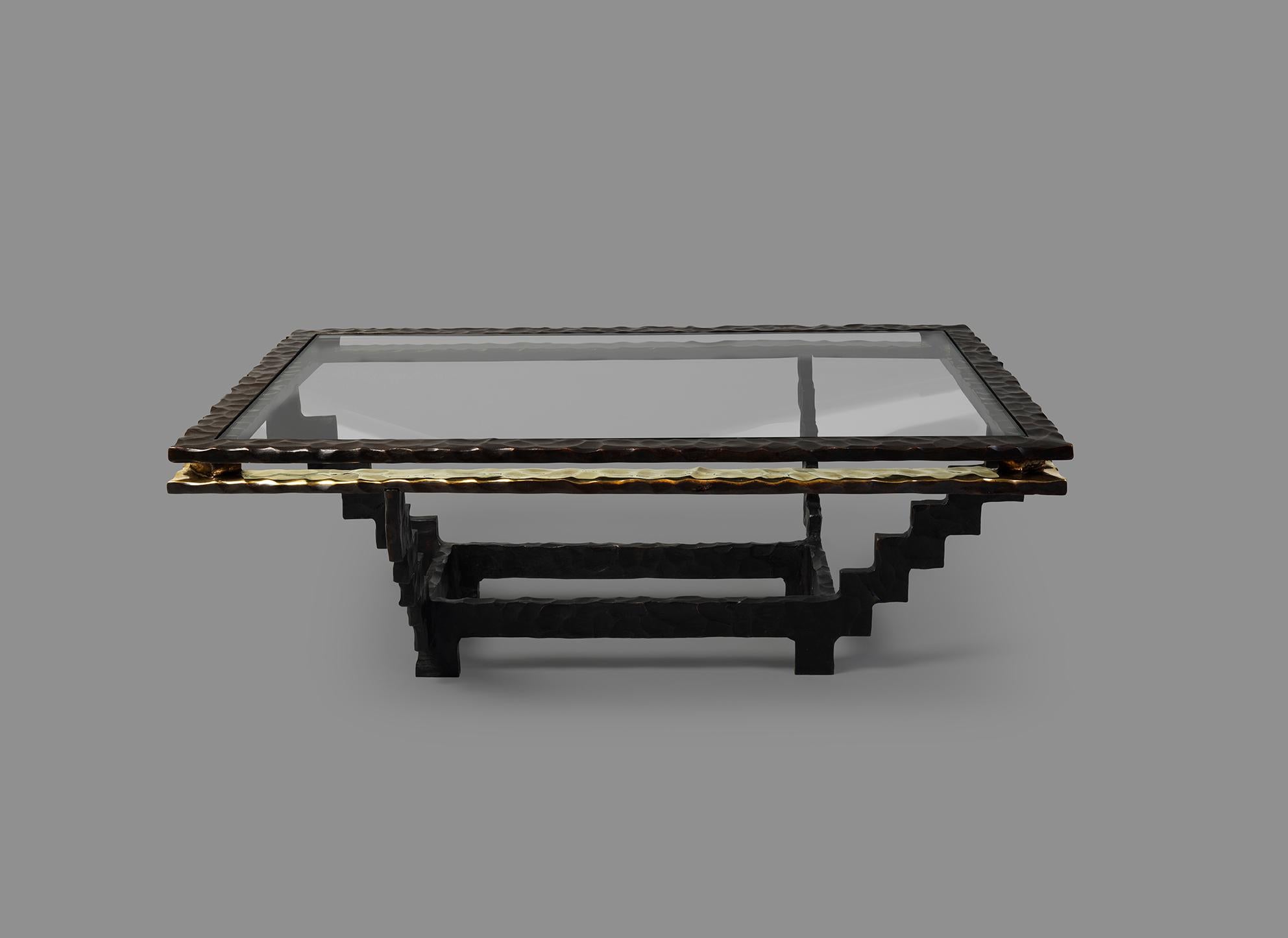 This sculptural bronze coffee table was inspired by the work of MC Escher and his 1953 lithograph 'Relativity', which depicts a world in which the normal laws of gravity do not apply. 

Cast in bronze by lost wax technique the interior of the top