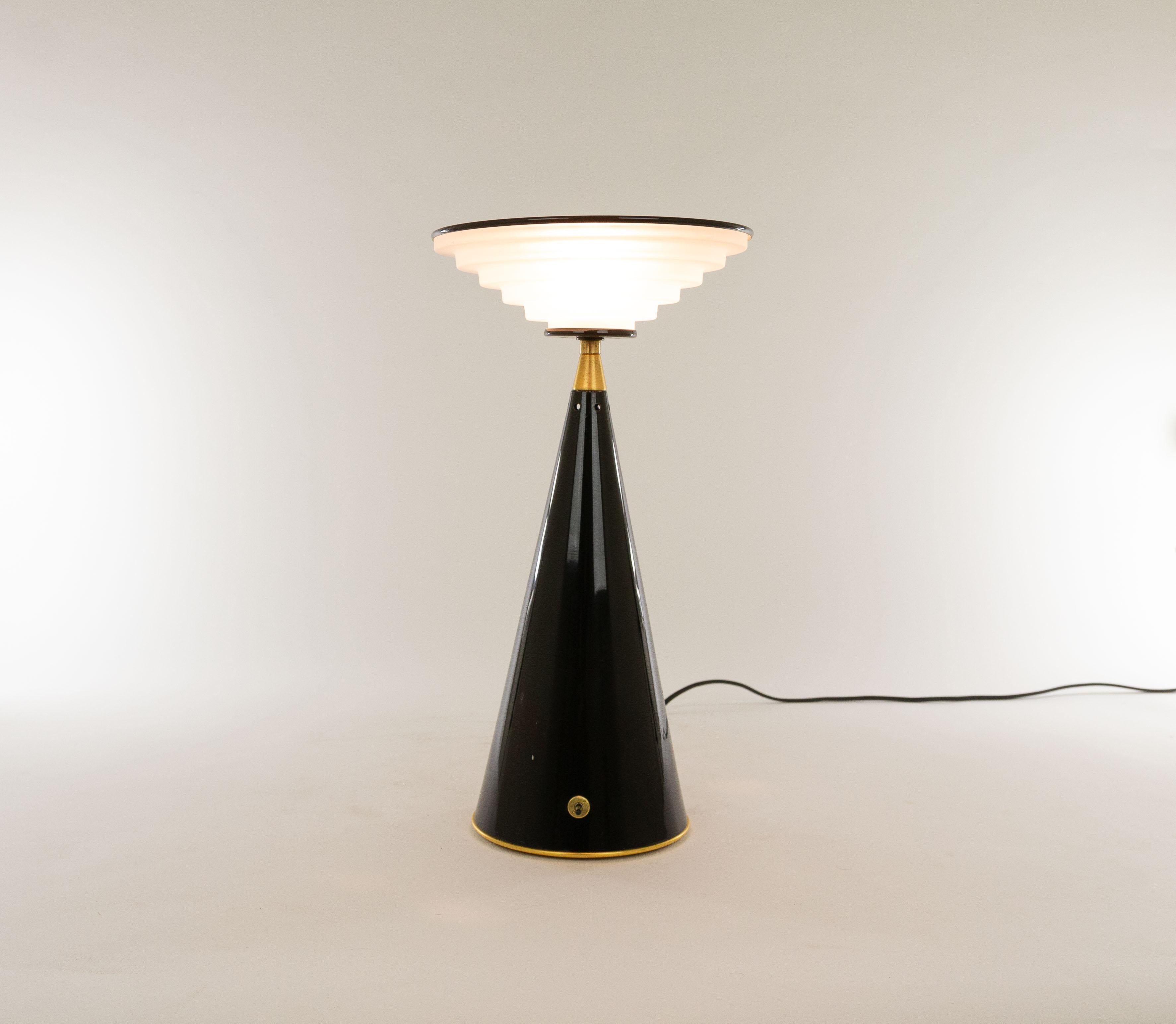 'Ziggurat' is a halogen table lamp designed by Shigeaki Asahara in 1981, and manufactured by Italian lighting manufacturer Stilnovo.

The lamp consists of a conical metal base and an inverted ziggurat-shaped moulded glass diffuser with a metal