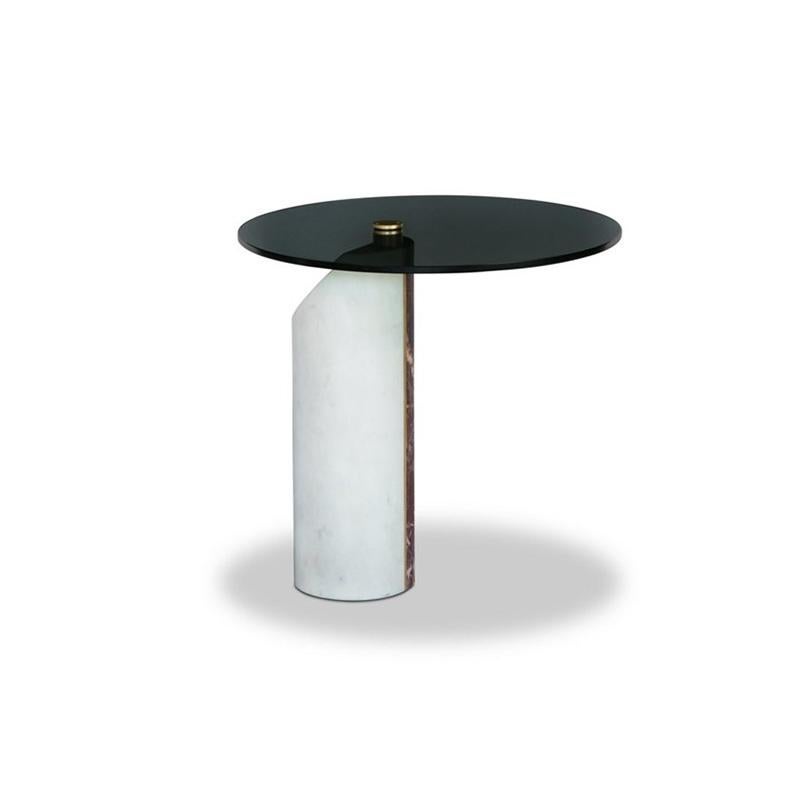 A side table with a revolving smoked glass top on a base composed of two different marble blocks - Smoothed Bianco Gioia and Hidro Rosso Lepanto. The base features a satin brass insert connected to the glass top. Any blemishes, that are attributable