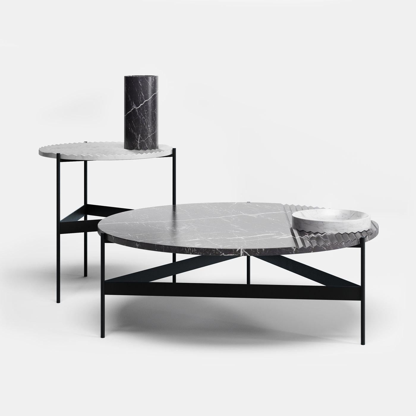 This coffee table stands out for the textural irony of its thick top in black Marquina marble, whose partially knurled surface is meant to be paired with the accessories in white Carrara marble (bowl and tray) designed with a knurled surface, too.