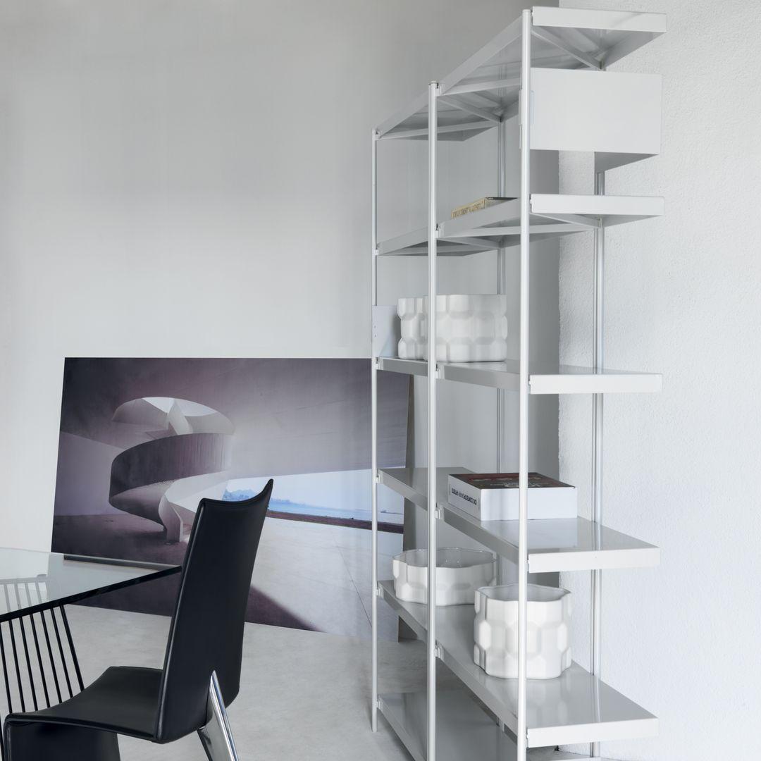 La structure en zigzag de l'étagère est simple et fraîche ; la palette de couleurs du travail du métal - noir, blanc, bronze et acier inoxydable poli - est complétée par deux types d'étagères en bois, en chêne et en noyer américain. Les serre-livres