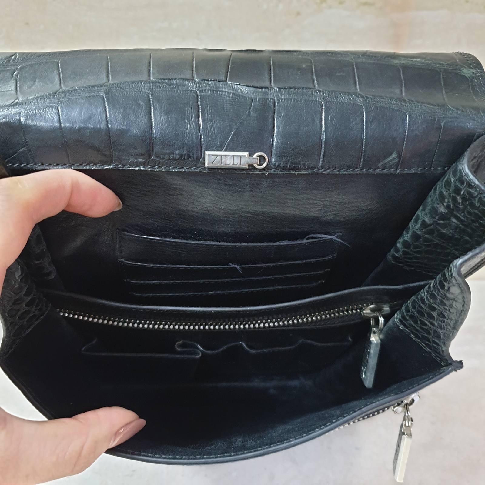 Zilli showcases an aura of casual luxury with its black alligator messenger bag. With buttery soft alligator leather of impeccable quality and a light and flexible construction, this flipped sling bag does not compromise on practicality.

The