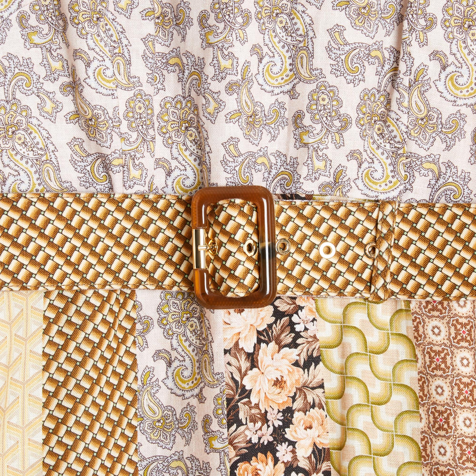 Vestido Zimmermann 2021 de patchwork de lino estampado con motivos geométricos y paisley que dan un tono general beige al vestido, cuello alto cerrado en la espalda por un lavallière sobre una cremallera y un gancho, cintura alta con cinturón