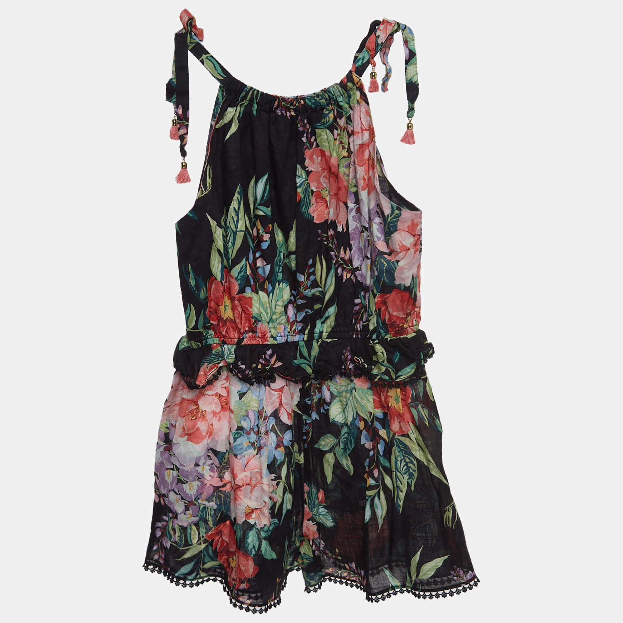 The Zimmermann playsuit is a charming one piece garment adorned with a stylish floral pattern. Crafted from comfortable and breathable cotton it features a playful design adjustable straps and a delightful blend of black and vibrant floral hues for