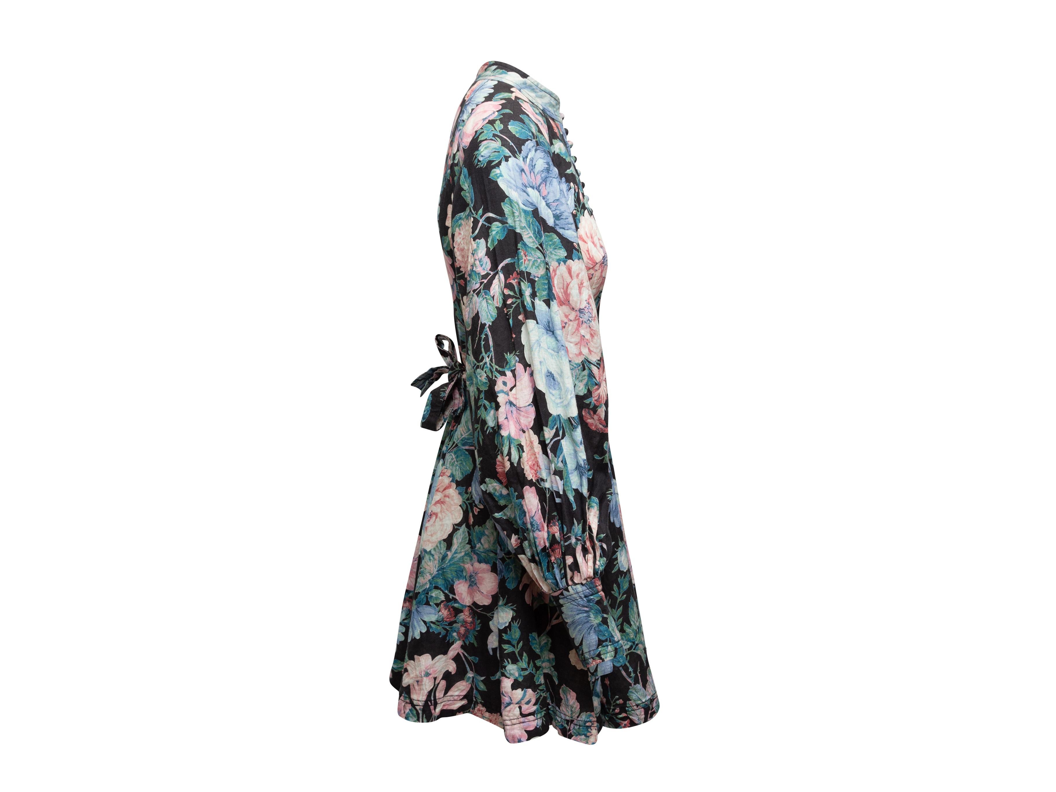 Product details: Black and multicolor linen floral print dress by Zimmermann. Long sleeves. Crew neck. Sash tie at waist. Button closures at center front. Designer size 1. 32
