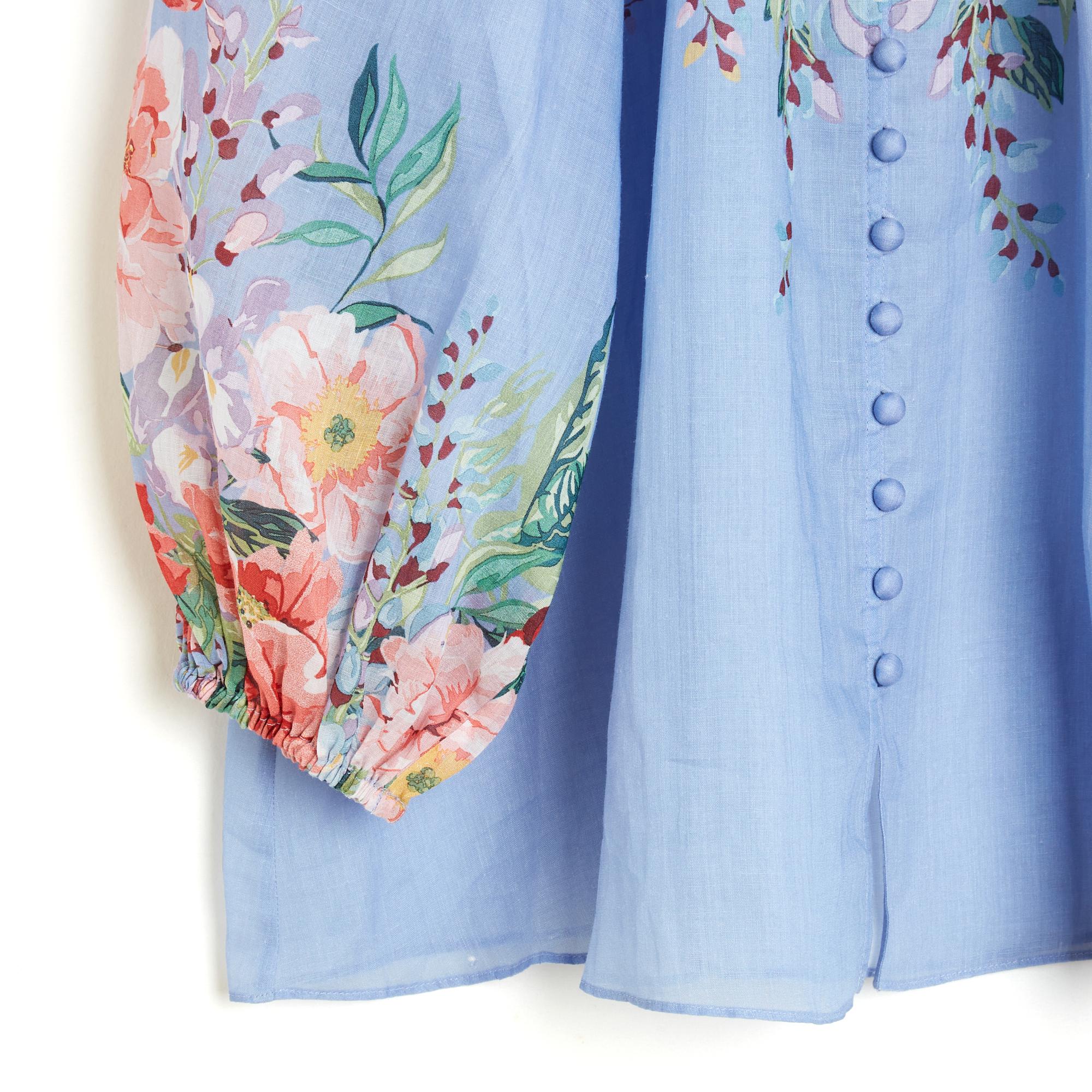 Top Zimmermann blouse model Ottie in ramie (natural plant material between cotton and linen) blue with floral pattern, high collar, closed by buttons dressed on the entire height, long balloon raglan sleeves tightened at the bottom by an elastic,