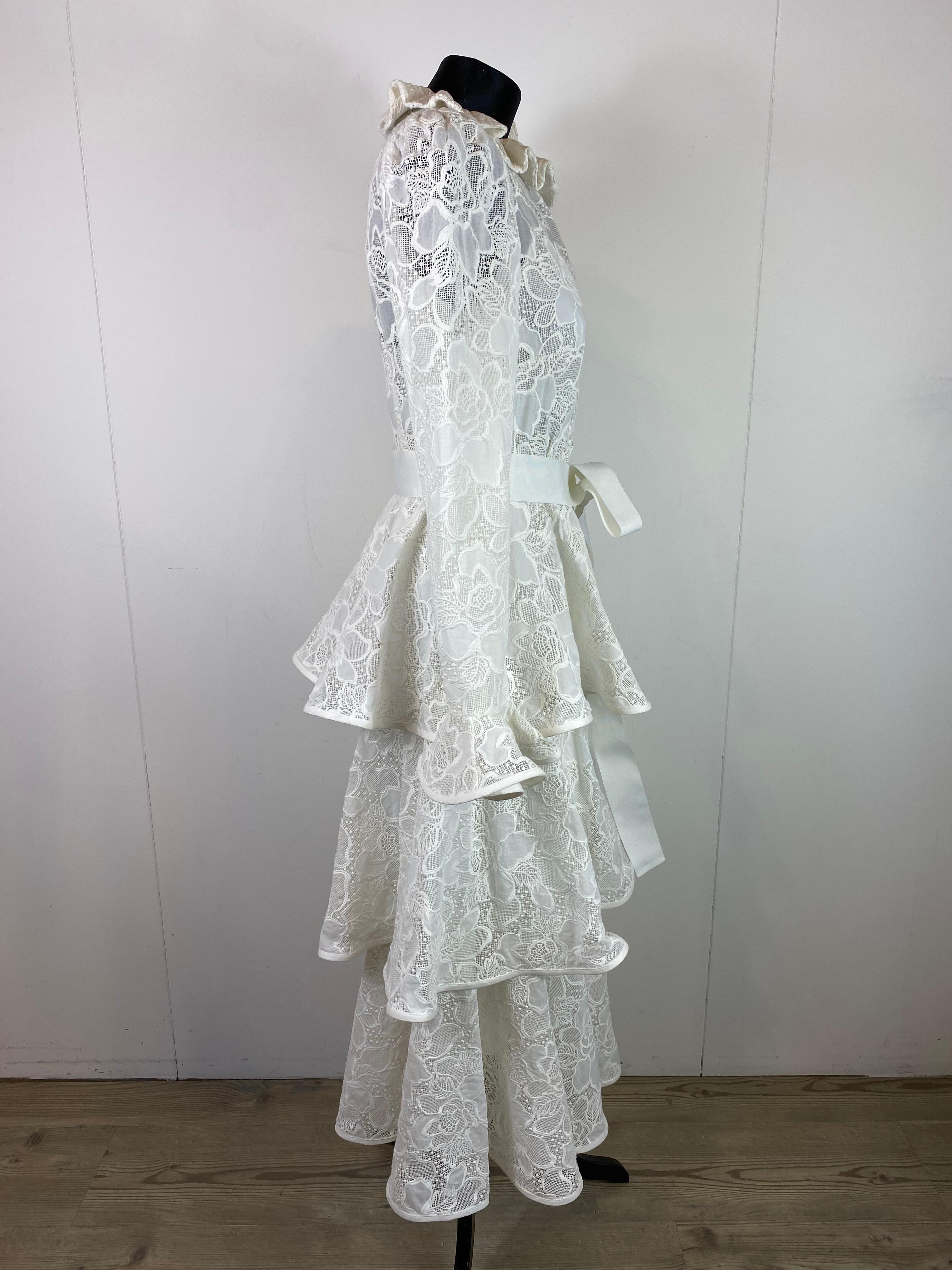 Zimmermann white dress in cotton broderie anglaise lace with linen lining.
Flounced skirt, puffed sleeves.
Invisible zip closure in the center back and waist belt.
With petticoat.
It is part of the Resort 2020 collection, worn by Lily Collins at the