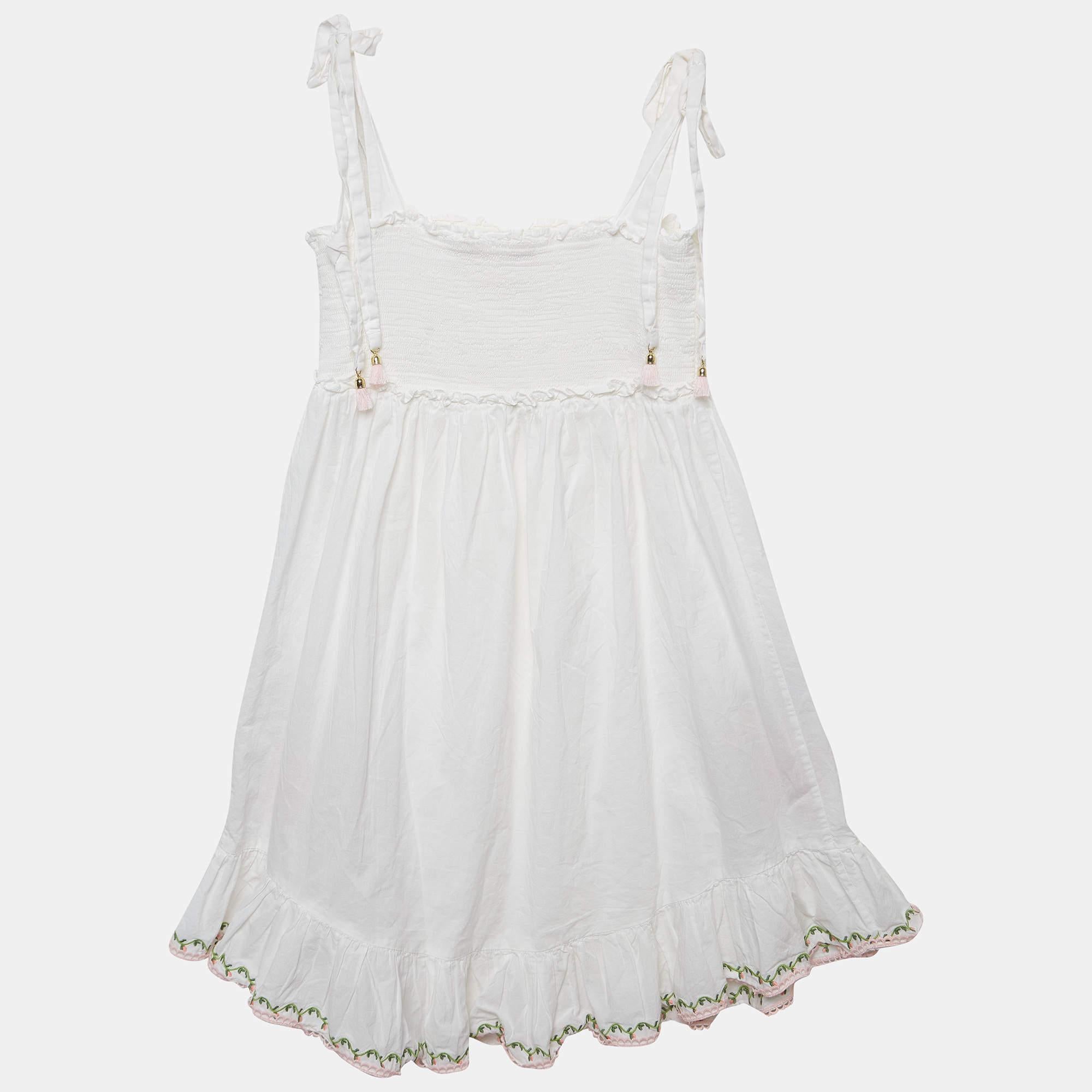 The Zimmermann White Embroidered Cotton Dress exudes timeless elegance. Delicate floral embroidery adorns the airy cotton fabric creating a romantic and feminine silhouette. With a fitted bodice flowing skirt and intricate details this dress