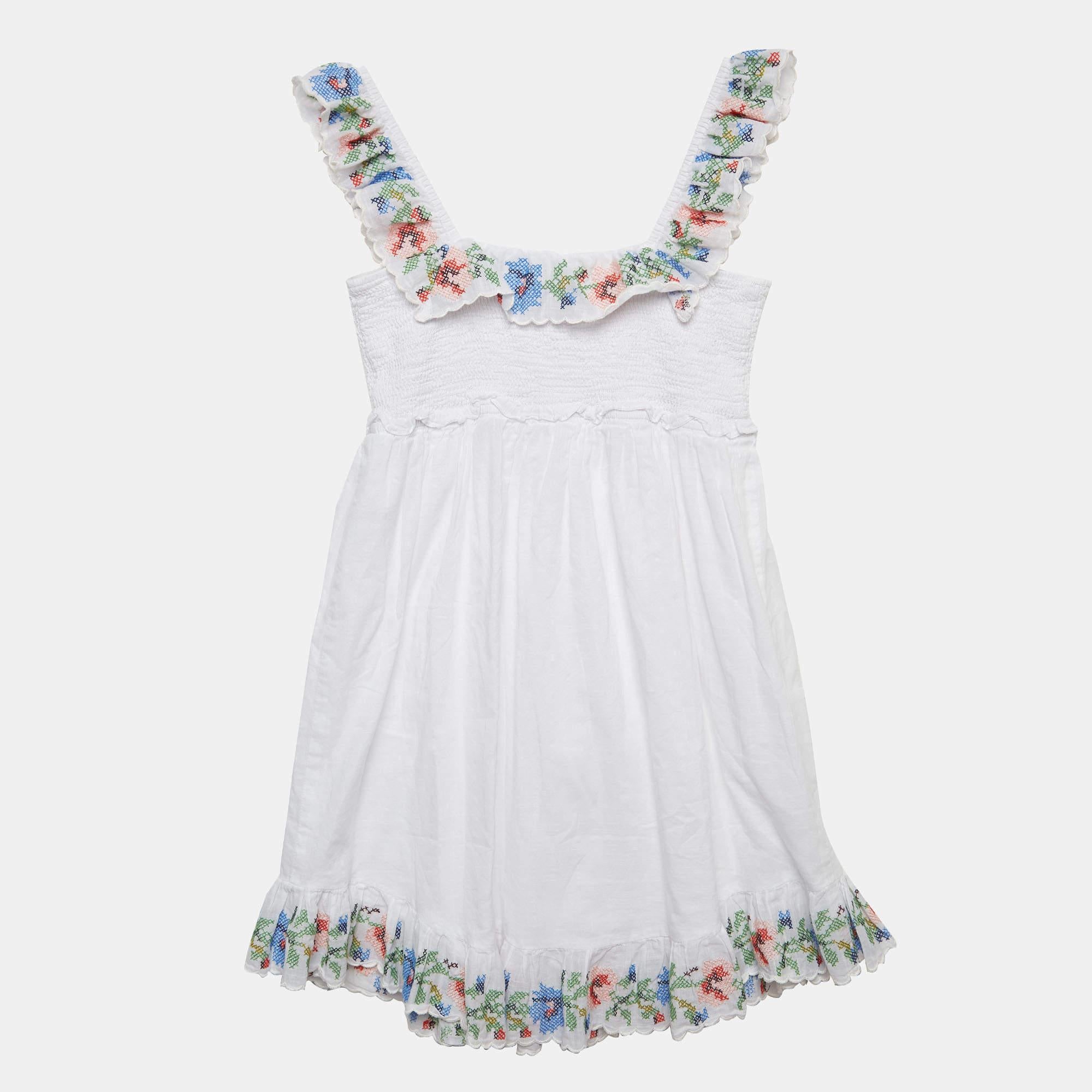 The Zimmermann dress exudes summertime charm. Crafted from high quality cotton it features delicate white embroidery creating a whimsical and elegant look. The dress is designed with meticulous attention to detail offering a perfect blend of comfort