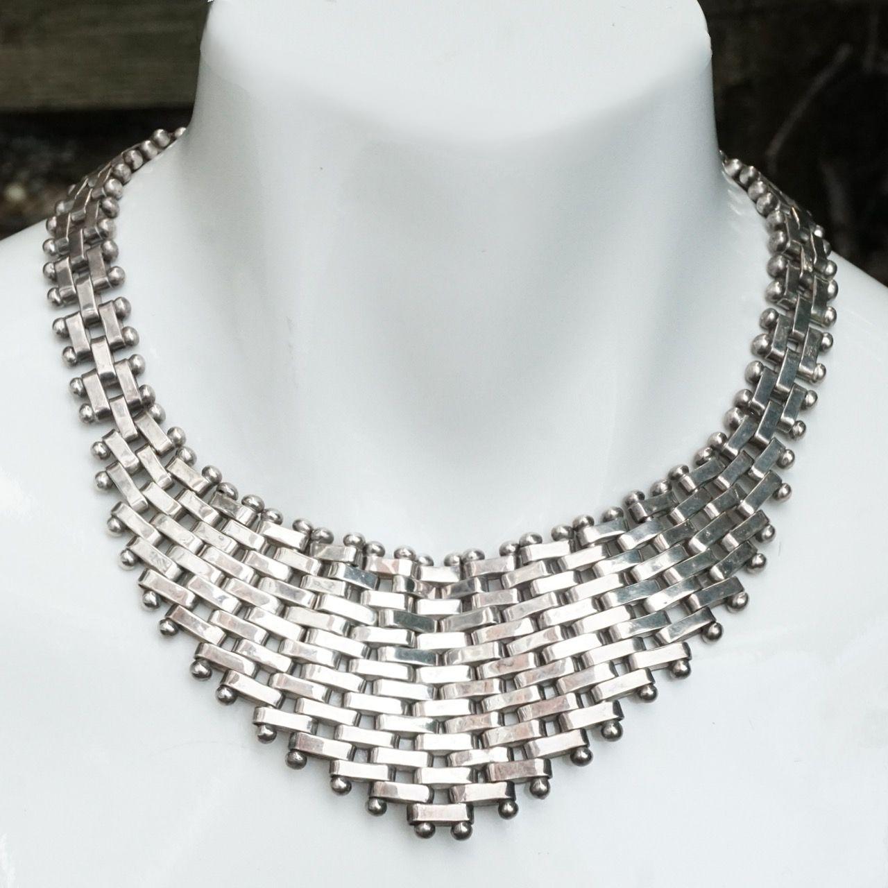 Favolosa collana a maglie in argento Zina con lavorazione a mattoni e bordatura a palline.  La collana è in ottime condizioni. Abbiamo dato una leggera pulita.

Misura circa 44,3 cm di lunghezza e 17,4 pollici di larghezza massima anteriore di 5,2