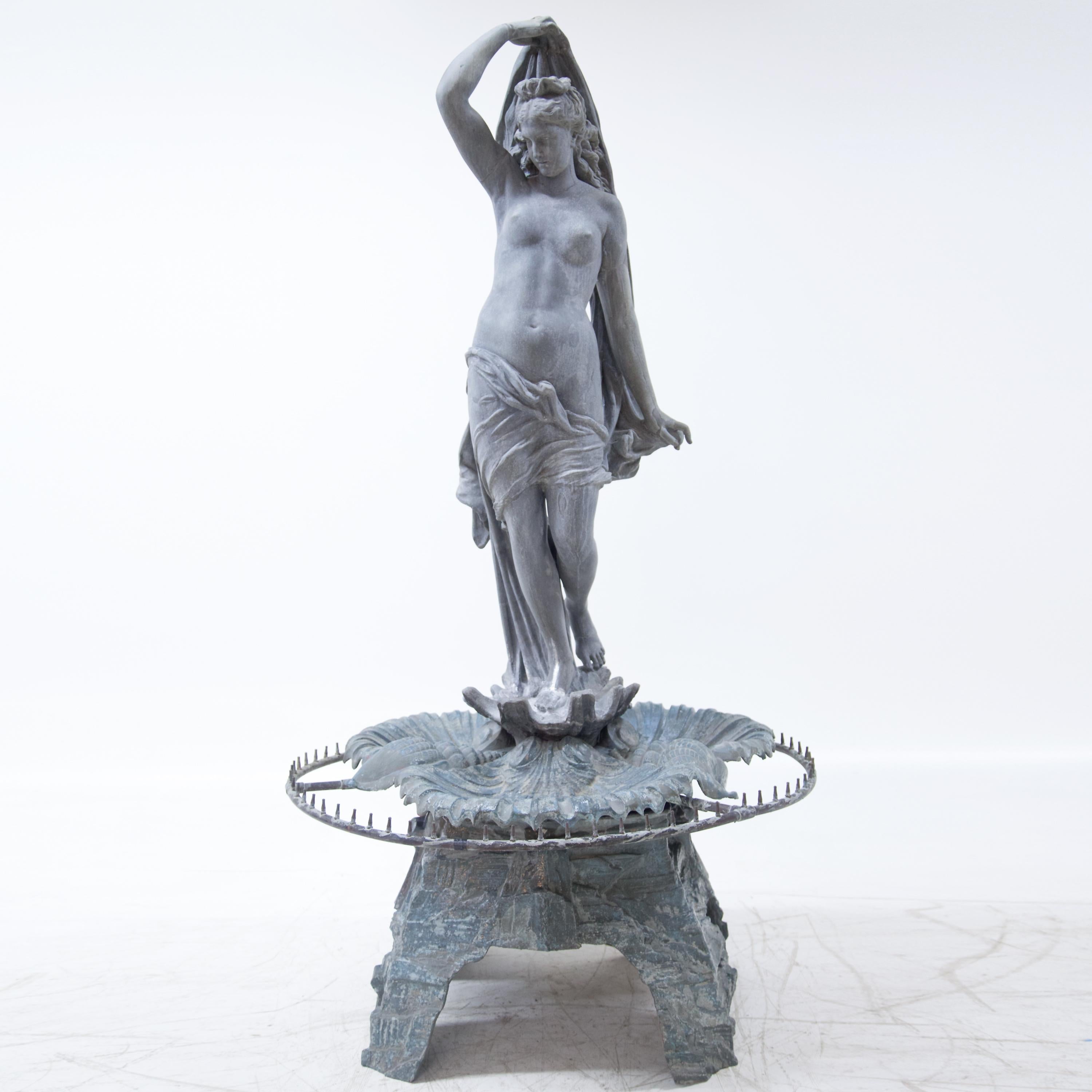 Large zinc fountain with life-size representation of Venus (h: 155cm) on stylized rock base with fountain wreath. The fountain was made 1880 by J. L. Mott Iron Works in New York and stood until 1986 at the corner 8th & Hall, St. Joseph, Missouri. In