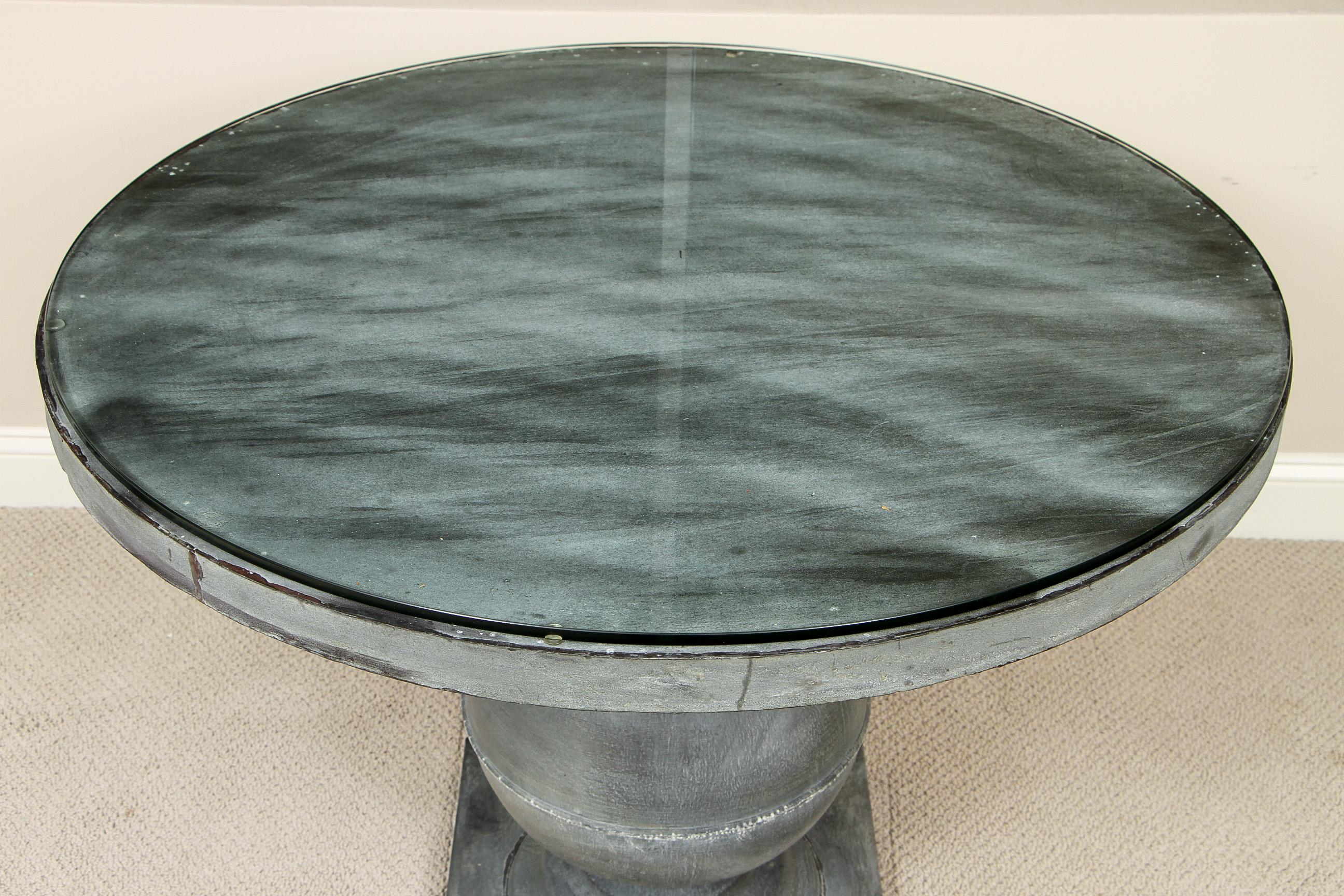 Industrial-style center hall table that gives a contemporary feel to a Classic form. A large circular top is supported on a spherical standard that stands on a square base. Accompanied with a 1/2