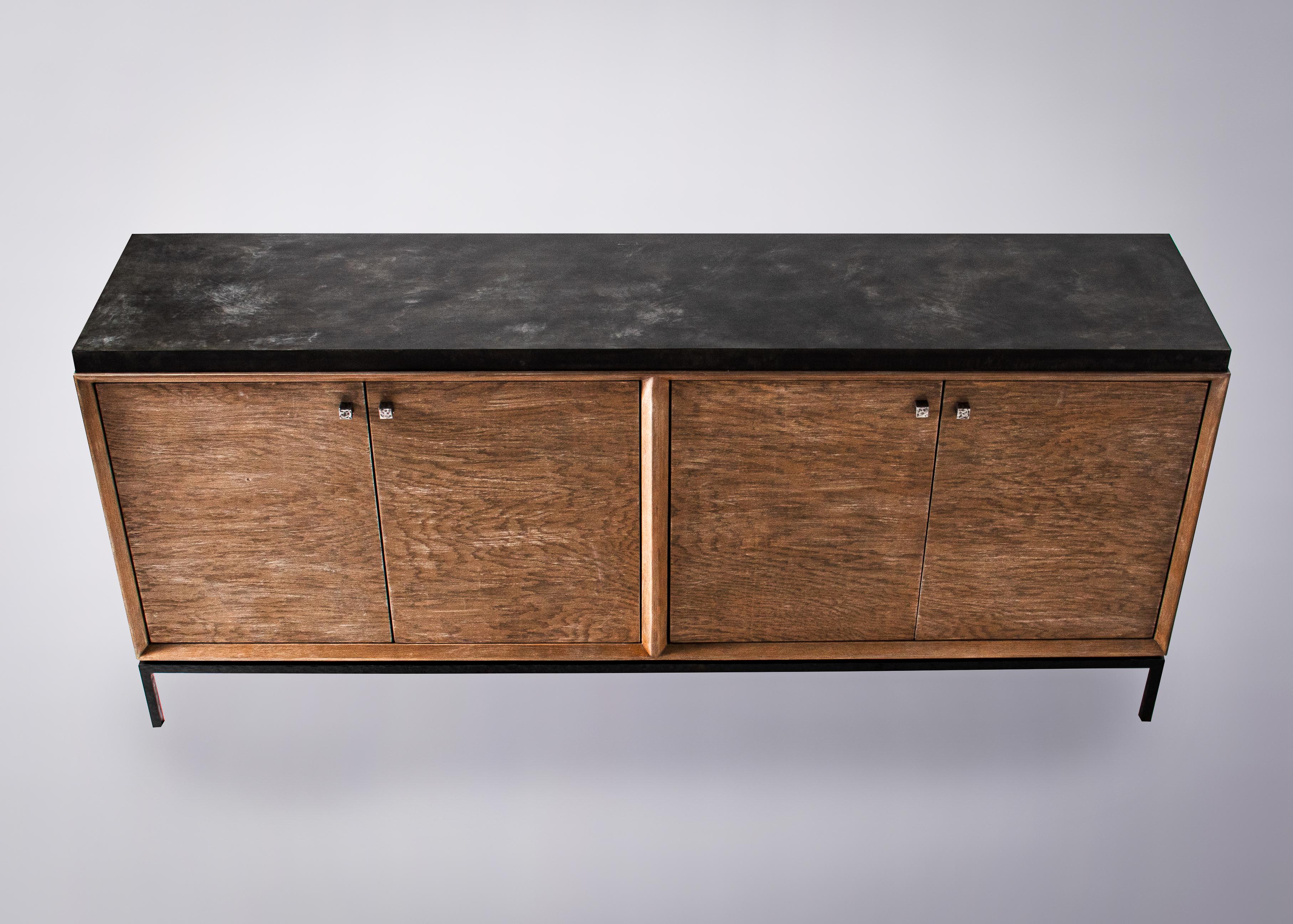 With a nod to mid-century design, this four-door cabinet is your stylish, sideboard solution.

Its custom feel is visible throughout. From the aged bronze, zinc top to the dark, hammered, steel base, this is a piece of furniture you can really call