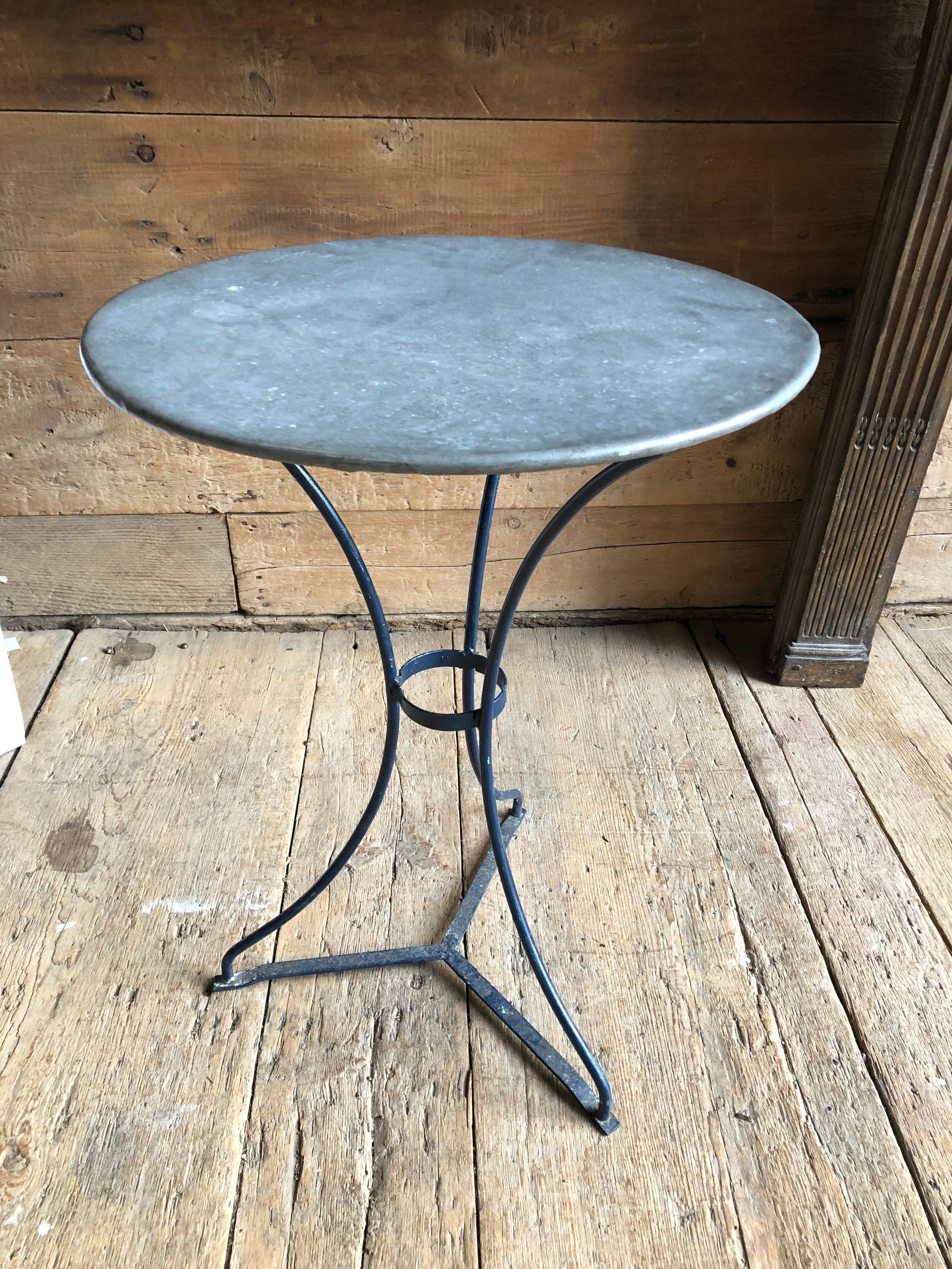 A small zinc top bistro table with a dark blue painted iron tripod base, French circa 1950.