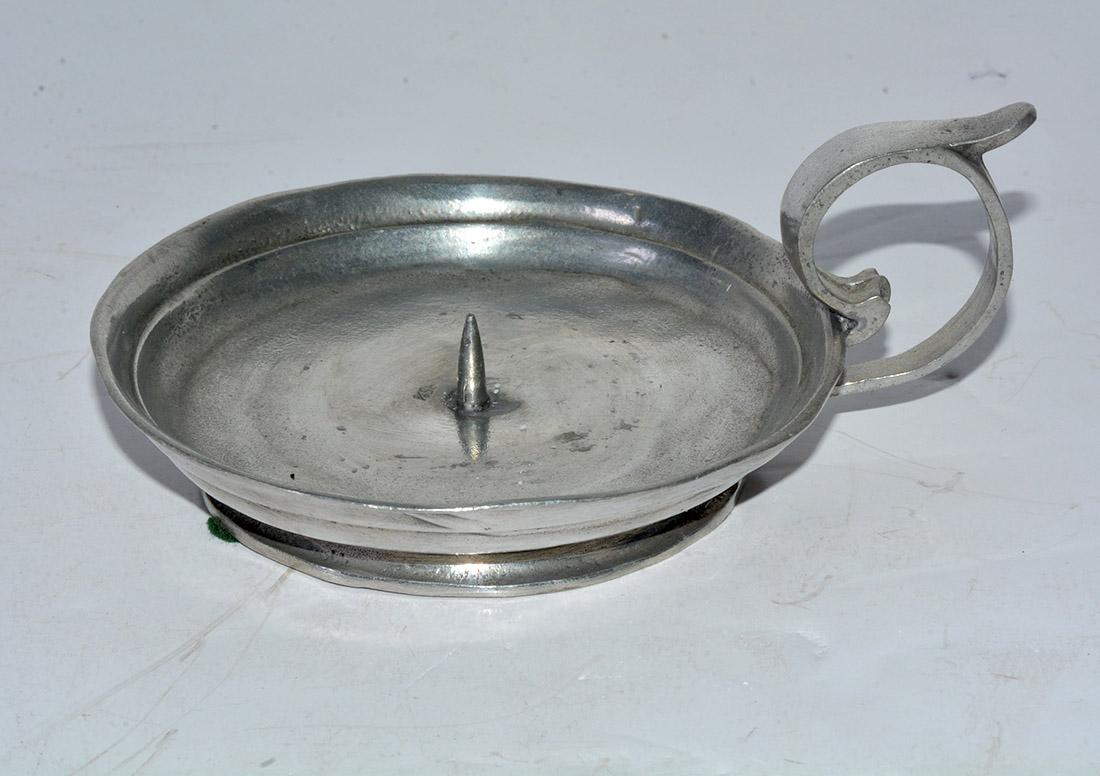 The pewter candleholder or chamber stick with spike has an imprinted bottom mark 