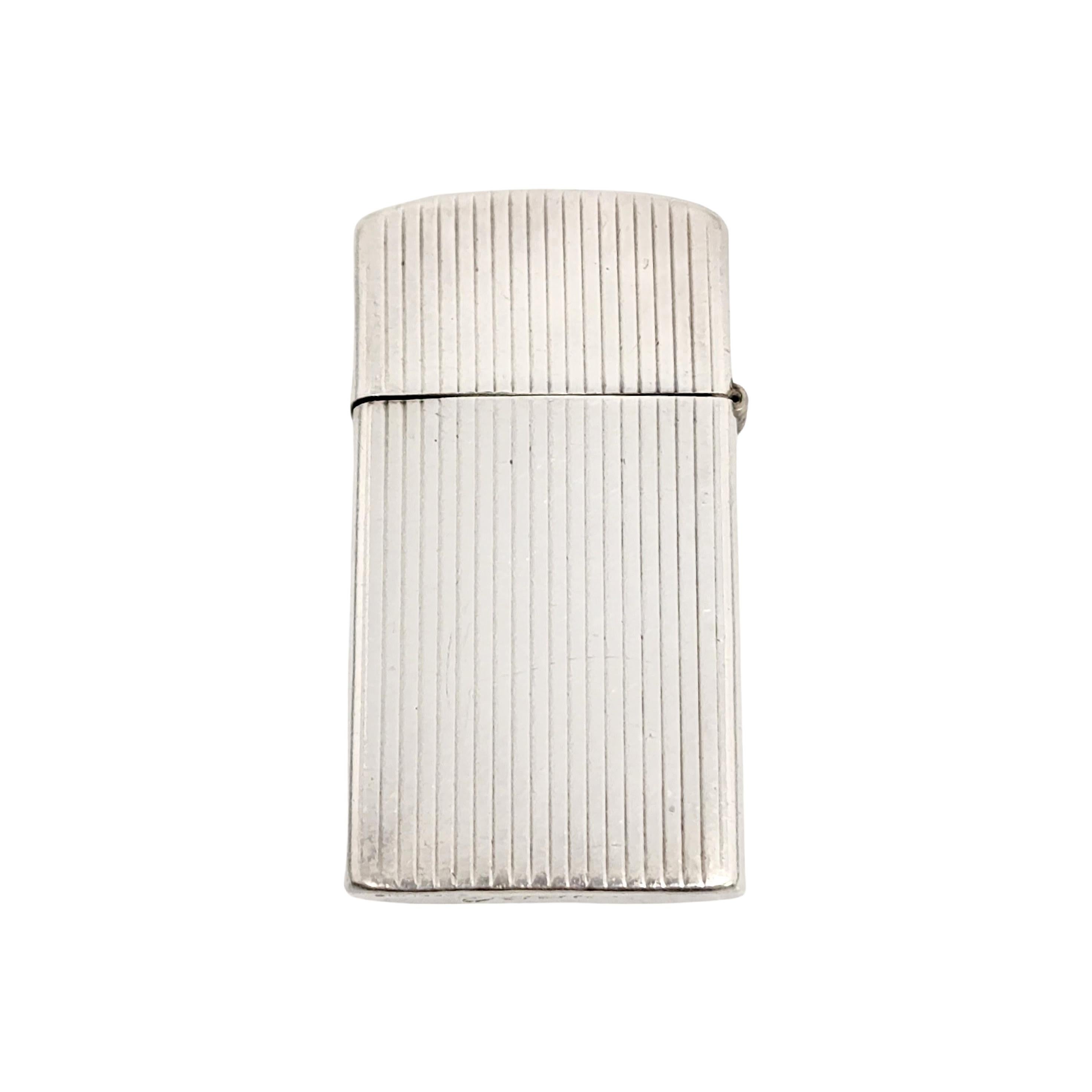 Zippo sterling silver slim lighter case with monogram, circa 1960.

Monogram appears to be MBK

A case for a Zippo Slim lighter of engine turned design featuring vertical lines. Monogram in a rectangular smooth polished cartouche. The slim date code