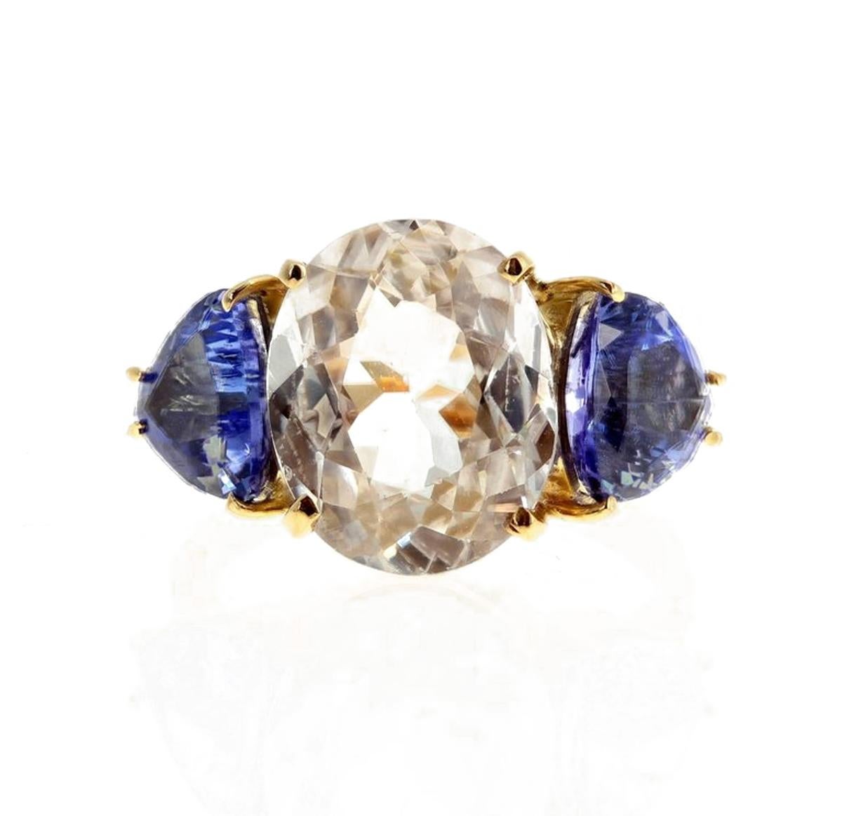 Glittering brilliant white natural real 5 carat Cambodian Zircon (12.2 mm x 9.6 mm) enhanced with sparkling natural blue Tanzanites (7 mm x 7.3 mm) set in a unique handmade 18Kt yellow gold ring size 5.5 (sizable for free). This gemstone is from the